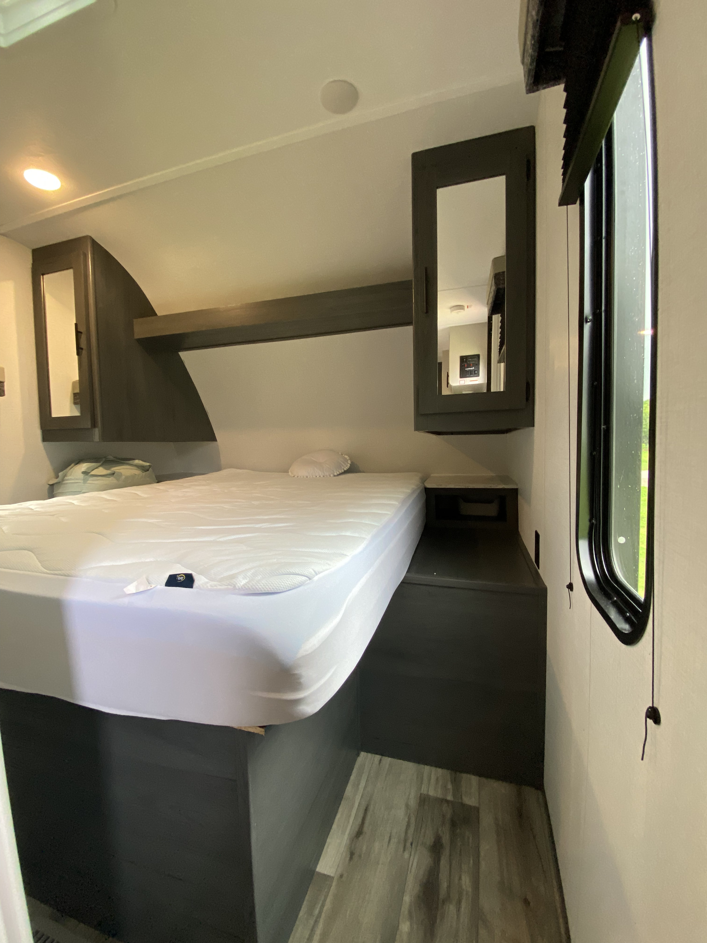 Compact and cozy RV bedroom interior, showcasing a comfortable bed and smart storage solutions. Ideal for your next RV rental journey.. Keystone RV Other 2024