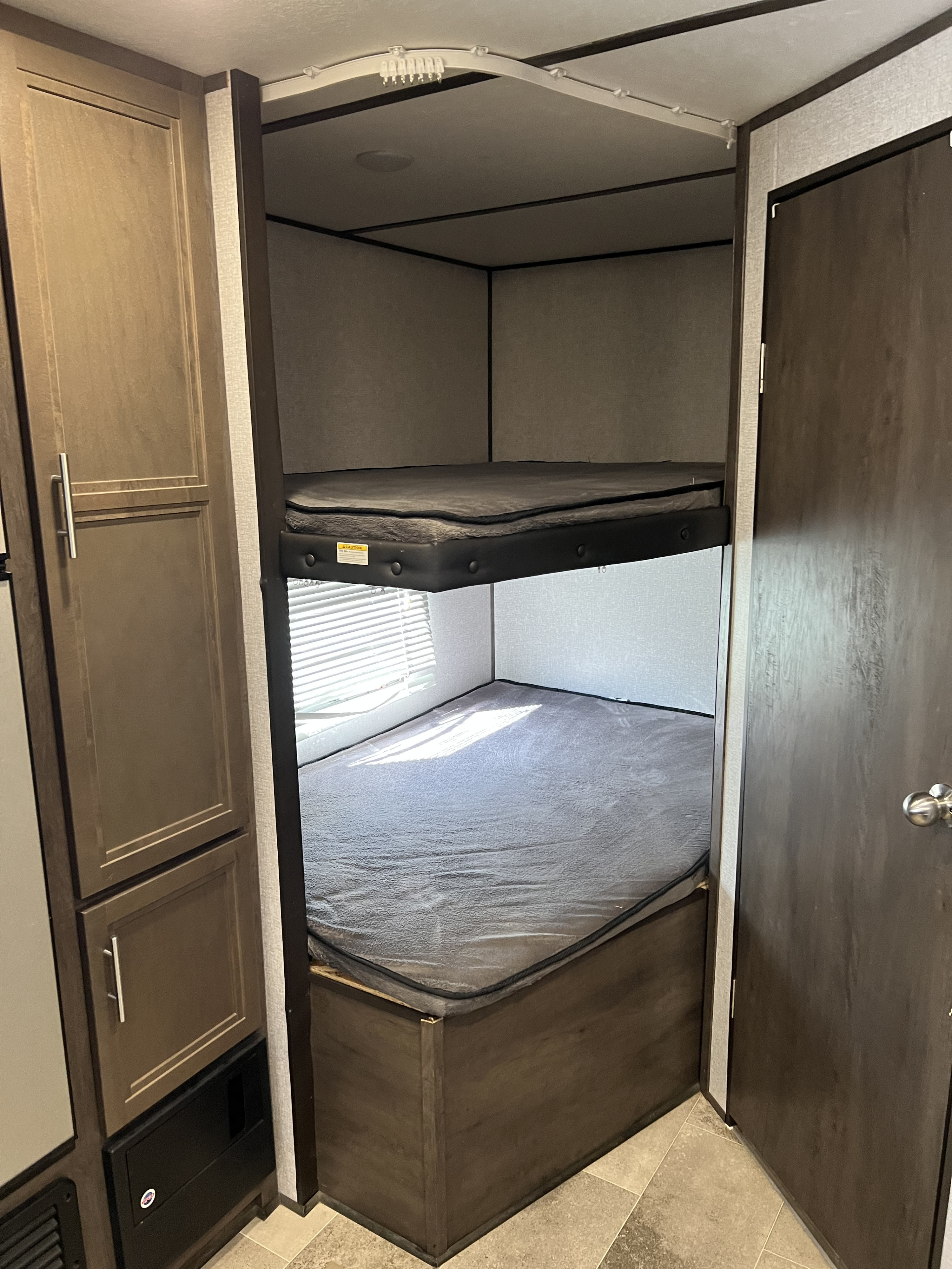 Inside this RV rental: comfortable, stacked bunk beds and useful cabinet storage optimize space.. Coleman Lantern 2021