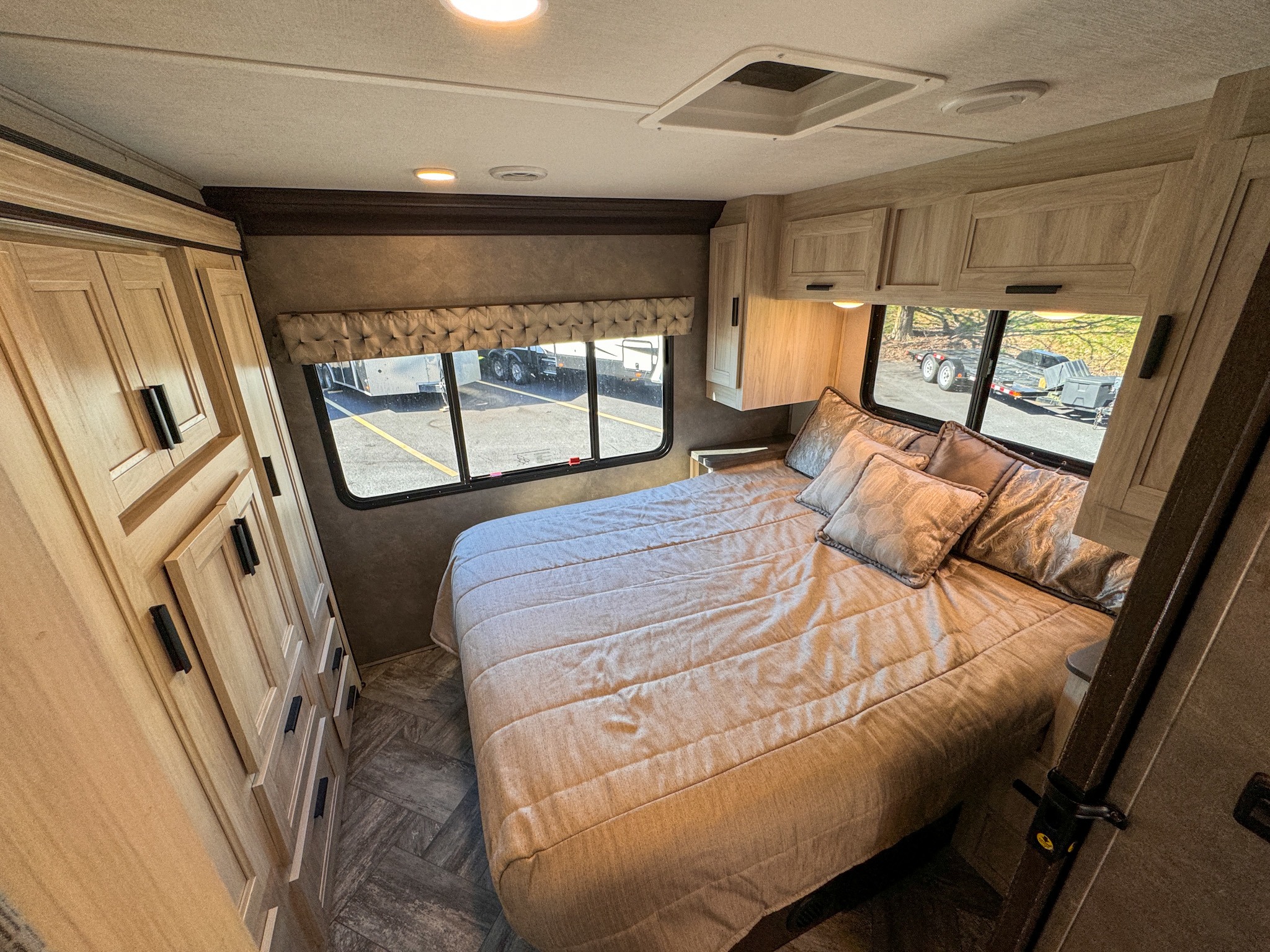 Comfortable RV rental bedroom featuring a large bed, built-. Forest River Sunseeker 2022