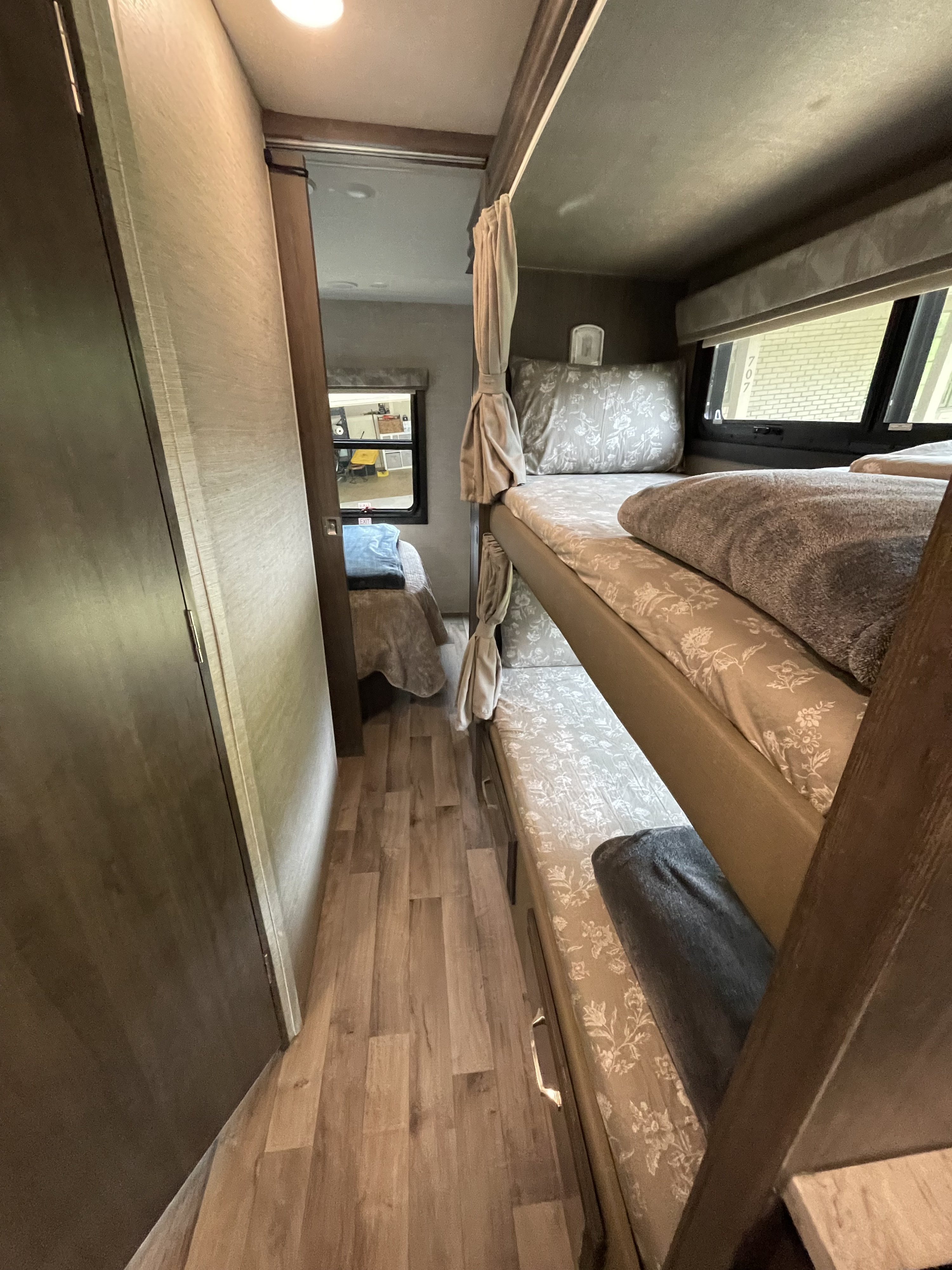 This RV rental features cozy bunk beds and a private bedroom at the end of the hallway, perfect for families.. Jayco Greyhawk 2023