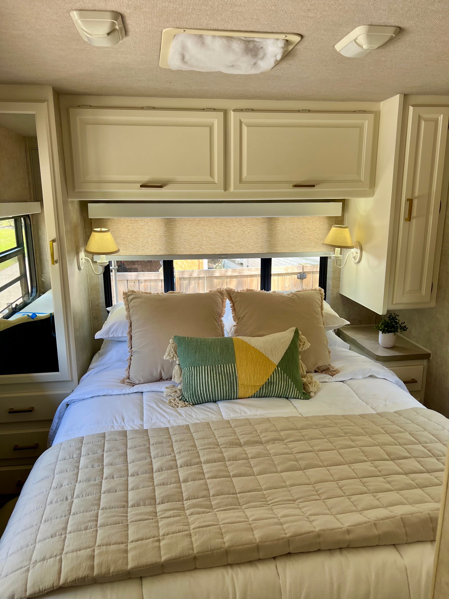 Well-appointed RV rental bedroom with a clean bed, overhead cabinets, and soft lighting for a comfortable stay.. Tioga Tioga Motorhome 2006