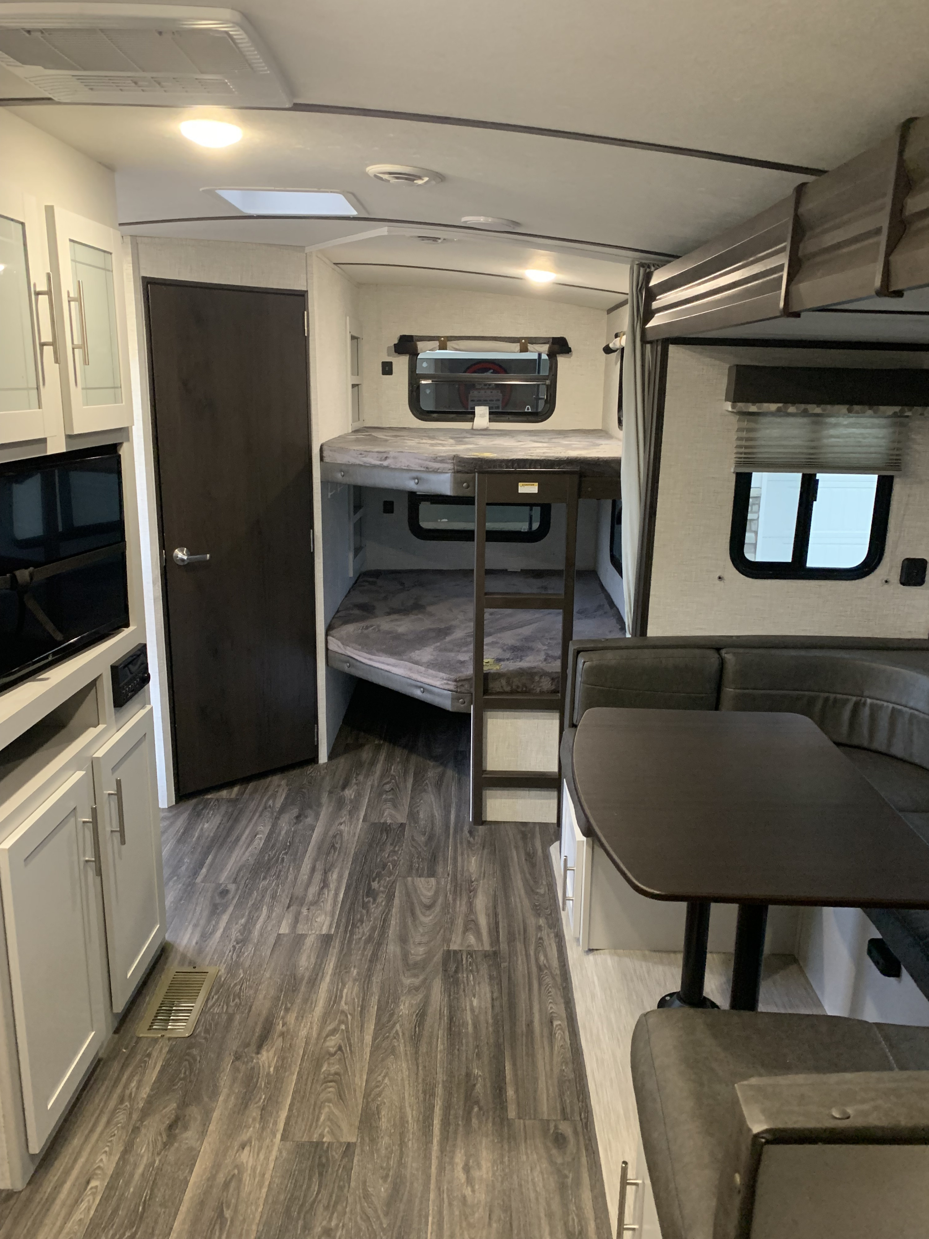 Spacious RV rental interior featuring bunk beds, a cozy dinette, and modern kitchen elements.. Keystone RV Bullet Ultra Lite 2021