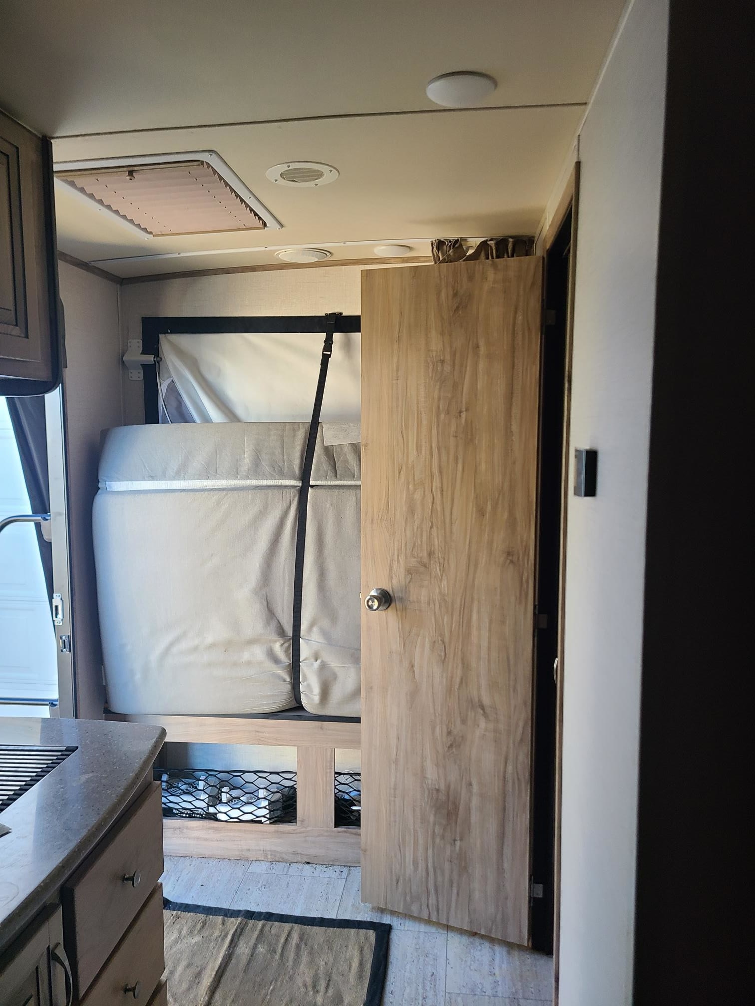 Compact rv rental interior with a space-saving fold-up bed, small kitchen, and wood accents, ideal for travel.. Palomino palomino solaire 163x 2018