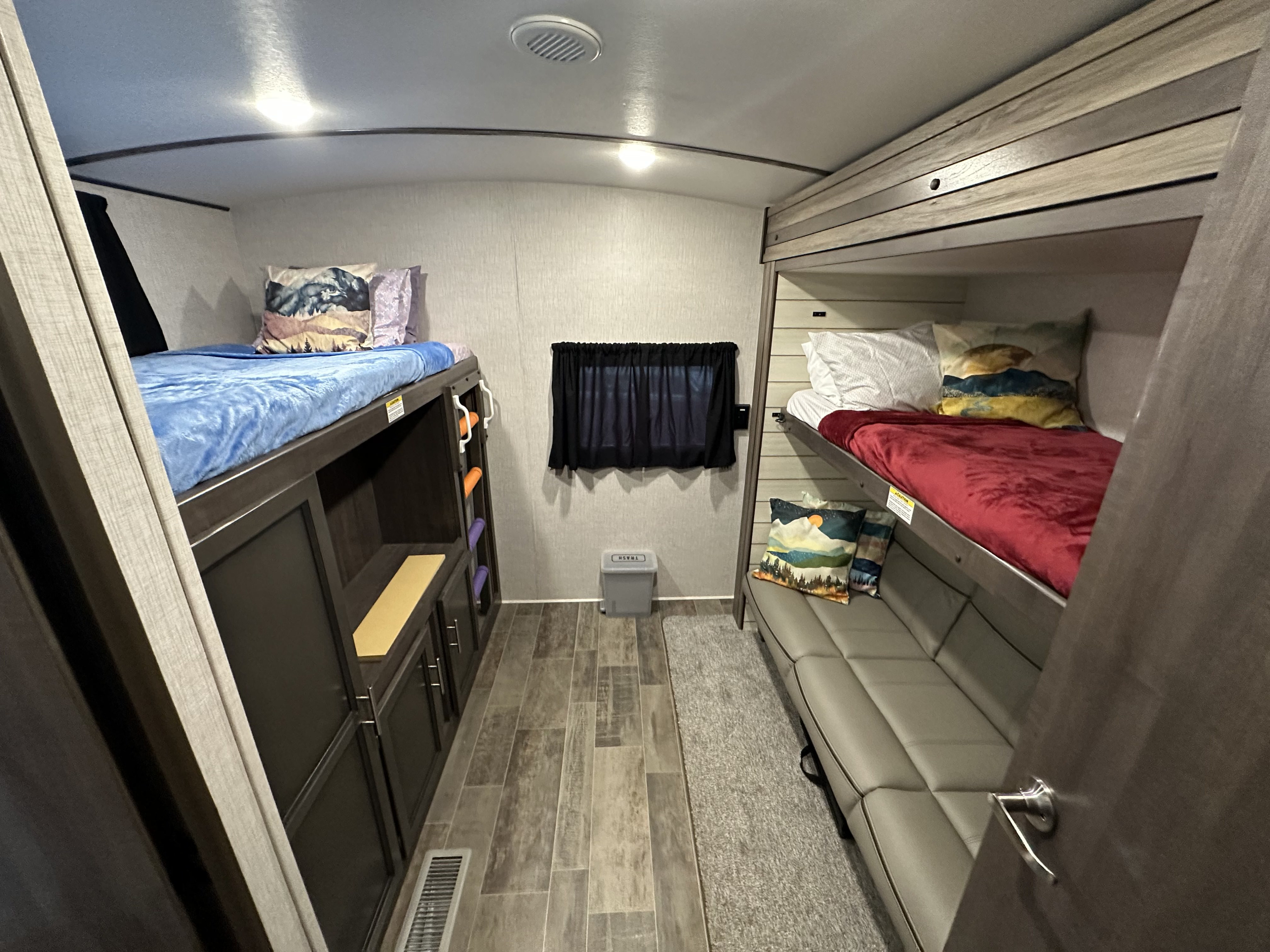 This RV rental offers comfortable bunk beds with colorful bedding, a sofa, and integrated storage.. Crossroads Sunset Trail 2021
