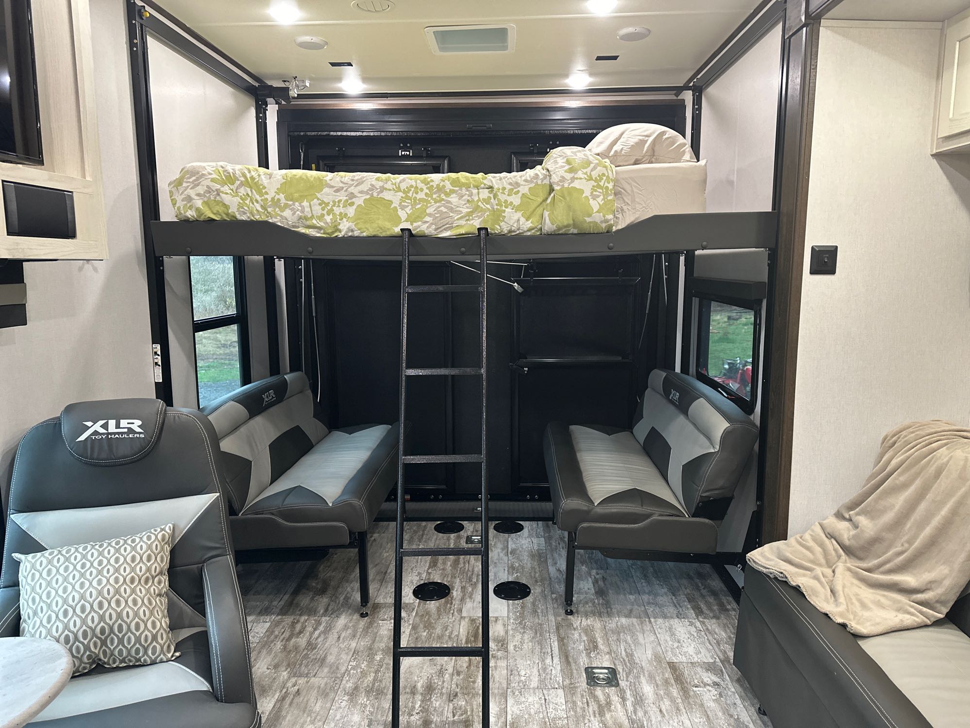 RV rental toy hauler interior. Features a power lift bunk bed, ladder, and versatile seating in the adaptable garage space.. Forest River Nitro Xlr 2021