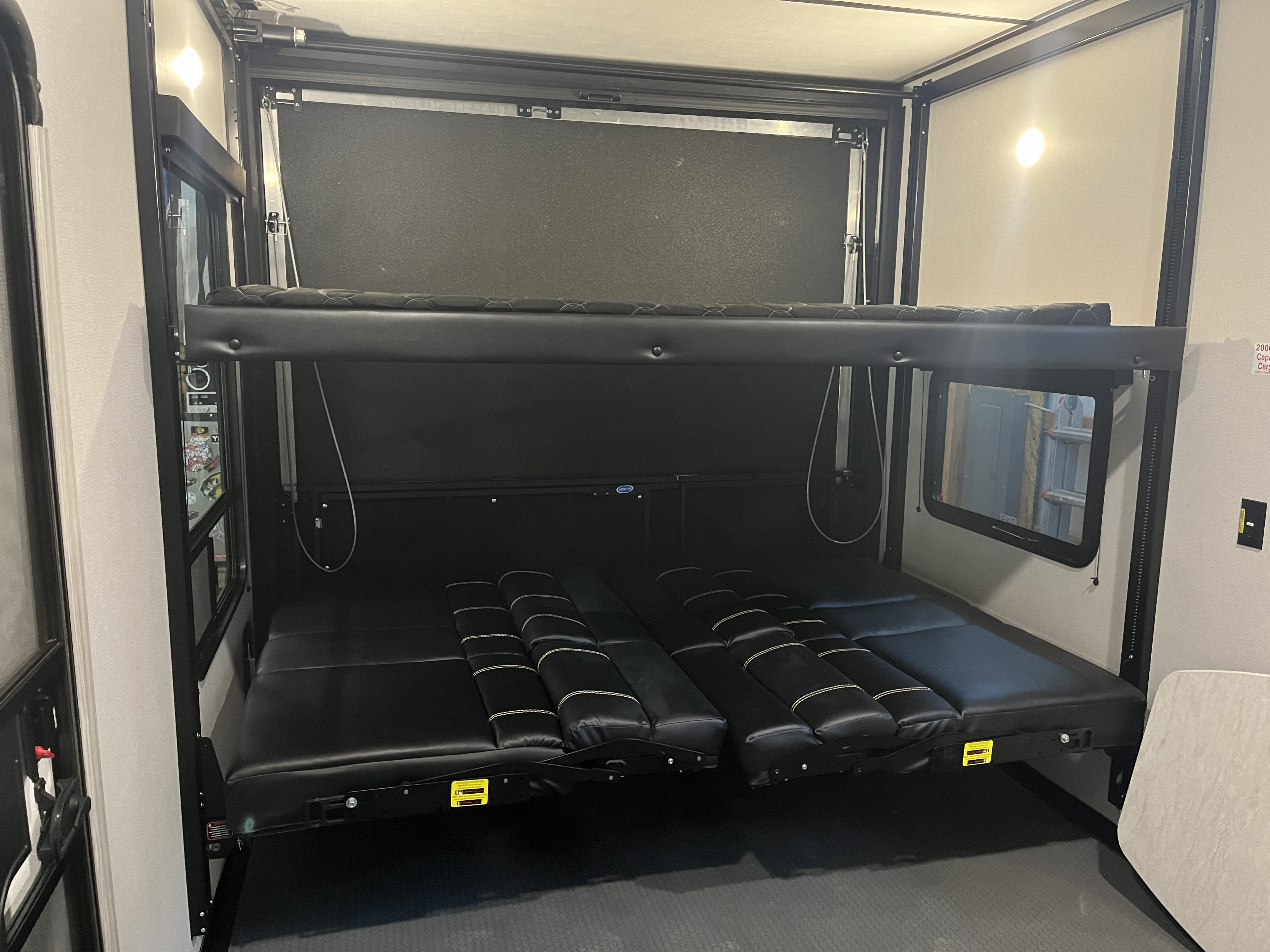 RV rental: Multi-level bunk beds and seating in a toy hauler's convertible garage space.. Keystone RV Fuzion Impact Toy Hauler 2022