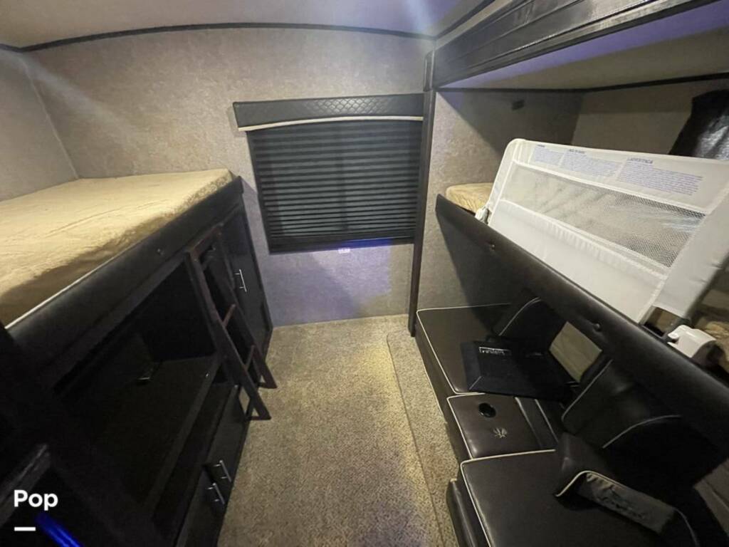 RV rental interior showcasing a bunkhouse: multiple beds, ladder, and a sofa. Ideal for family travel.. Jayco Eagle HT 2019