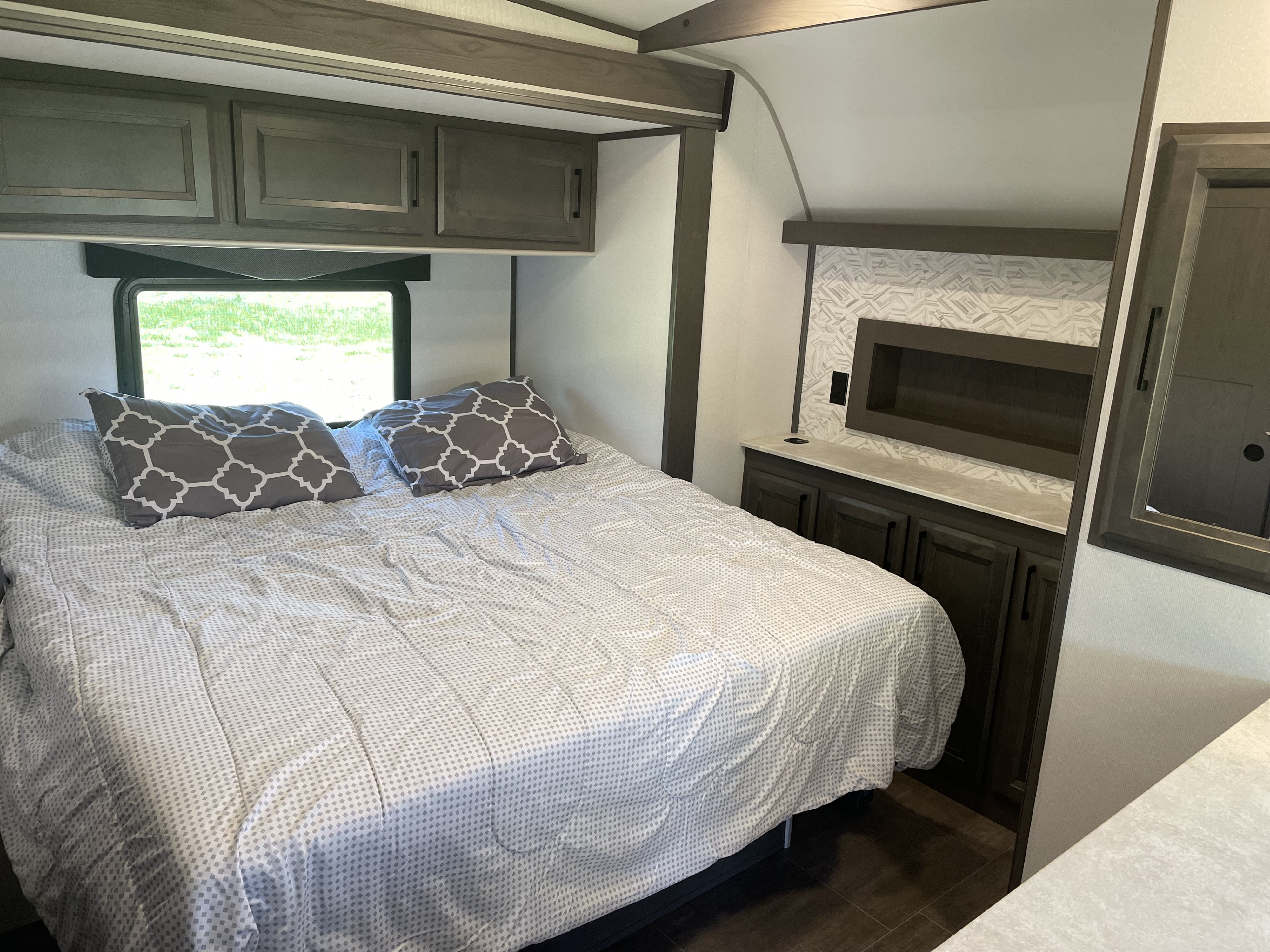 Comfortable RV rental bedroom with patterned bed, overhead cabinets, and built-in storage. Ideal for travel.. Cruiser Rv Corp Stryker 2021