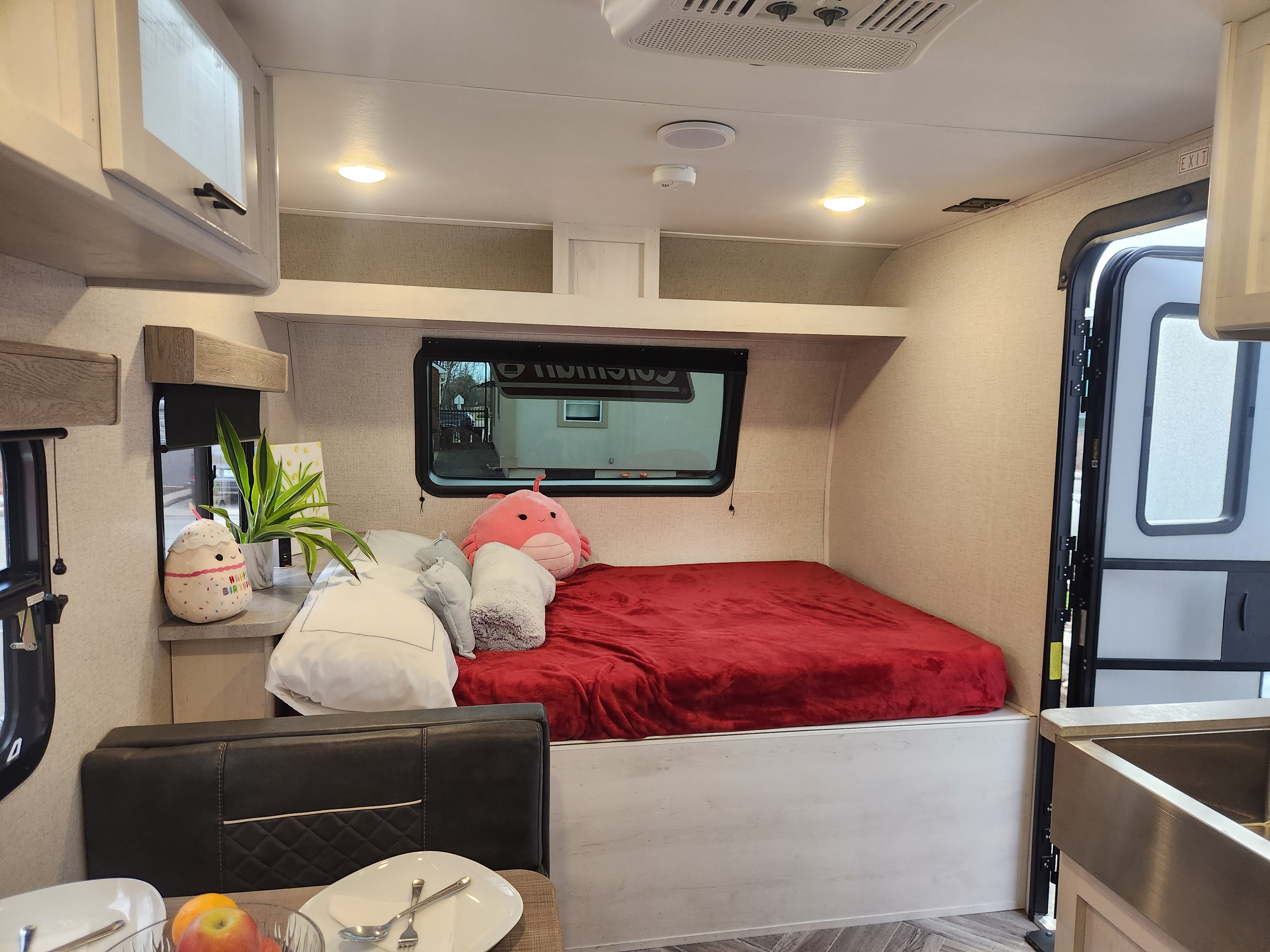 Cozy RV rental interior with a comfy bed, compact living area, and bright lighting, perfect for travel adventures.. Dutchmen Coleman Rubicon 2021