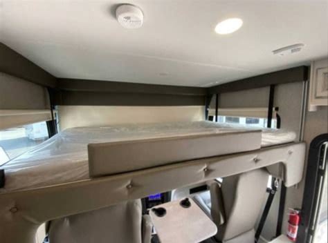 RV rental interior: Front overhead bunk bed with new mattress and safety features for travel.. Jayco Precept 2023