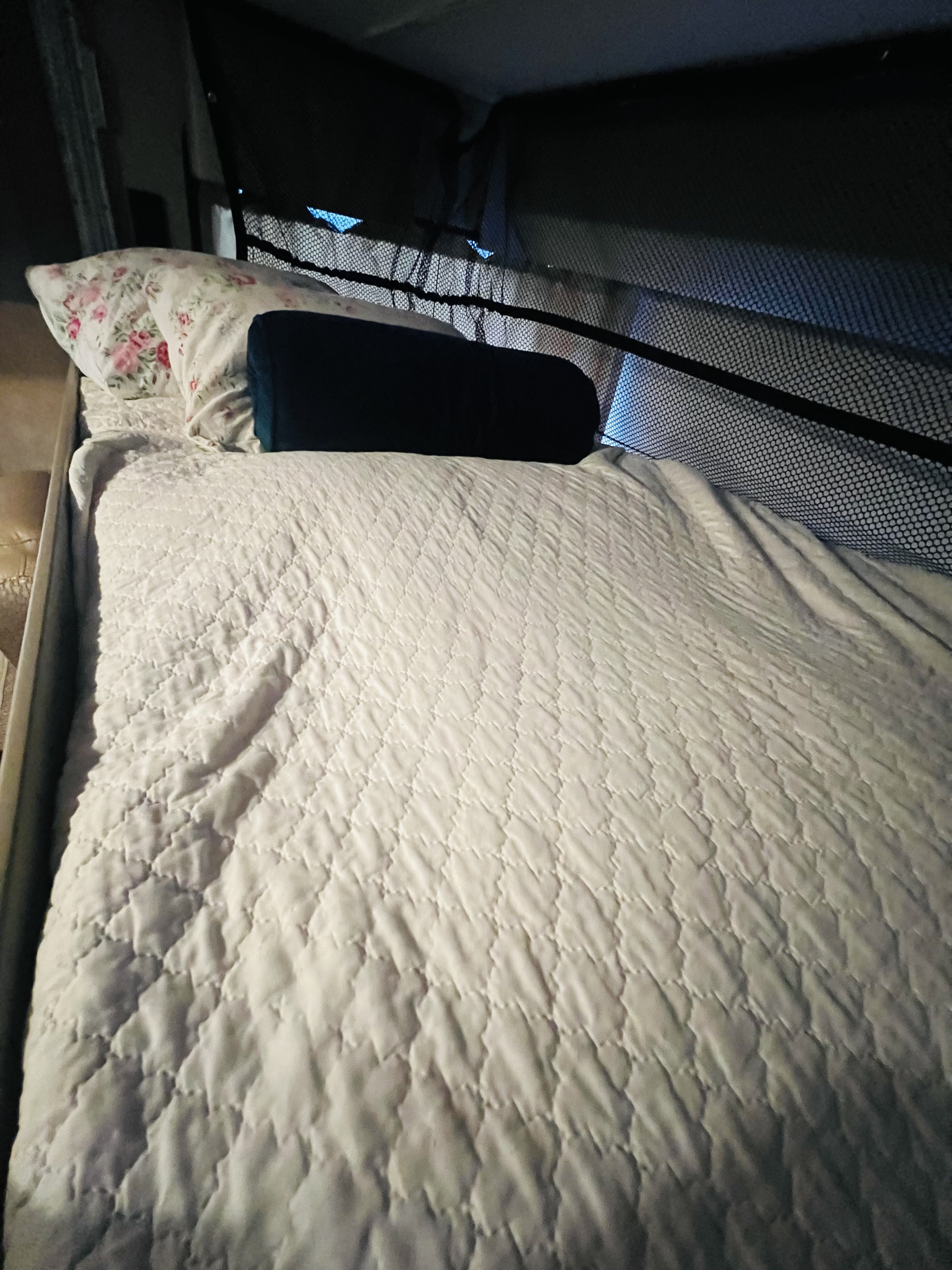 Comfortable RV rental bed with quilted comforter and floral pillow, ready for restful travel.. Thor Vegas 2016