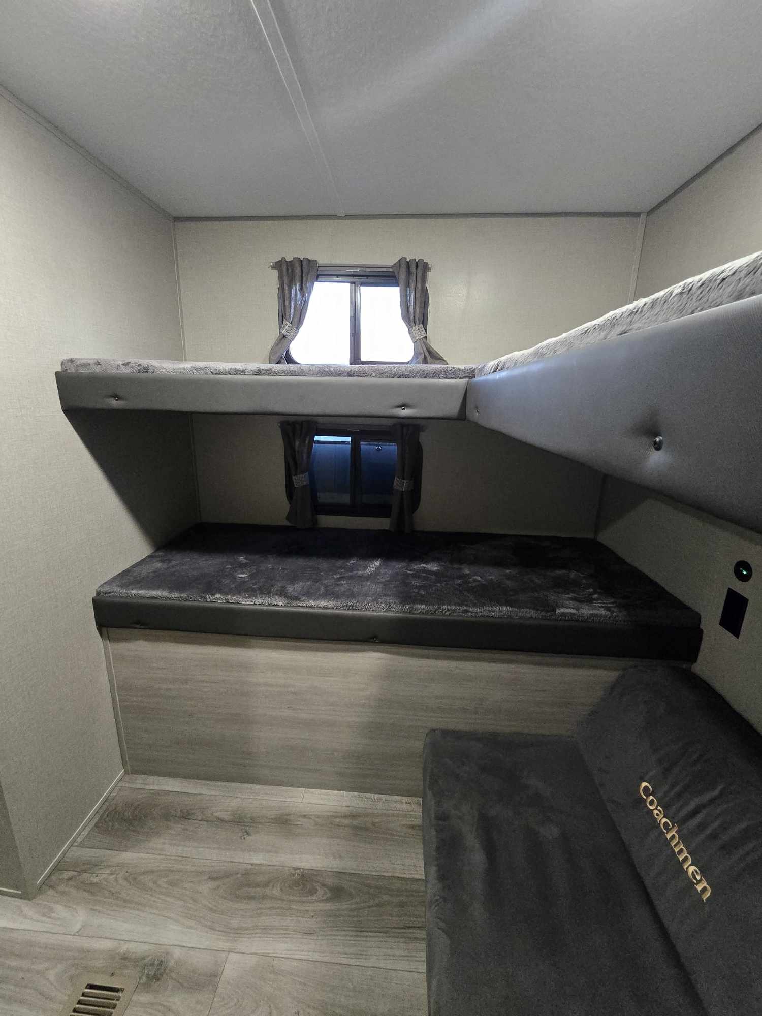 Compact RV rental interior featuring two comfortable bunk beds with soft covers, ideal for family sleeping quarters.. Coachmen Catalina Legacy 293QBCK 2023