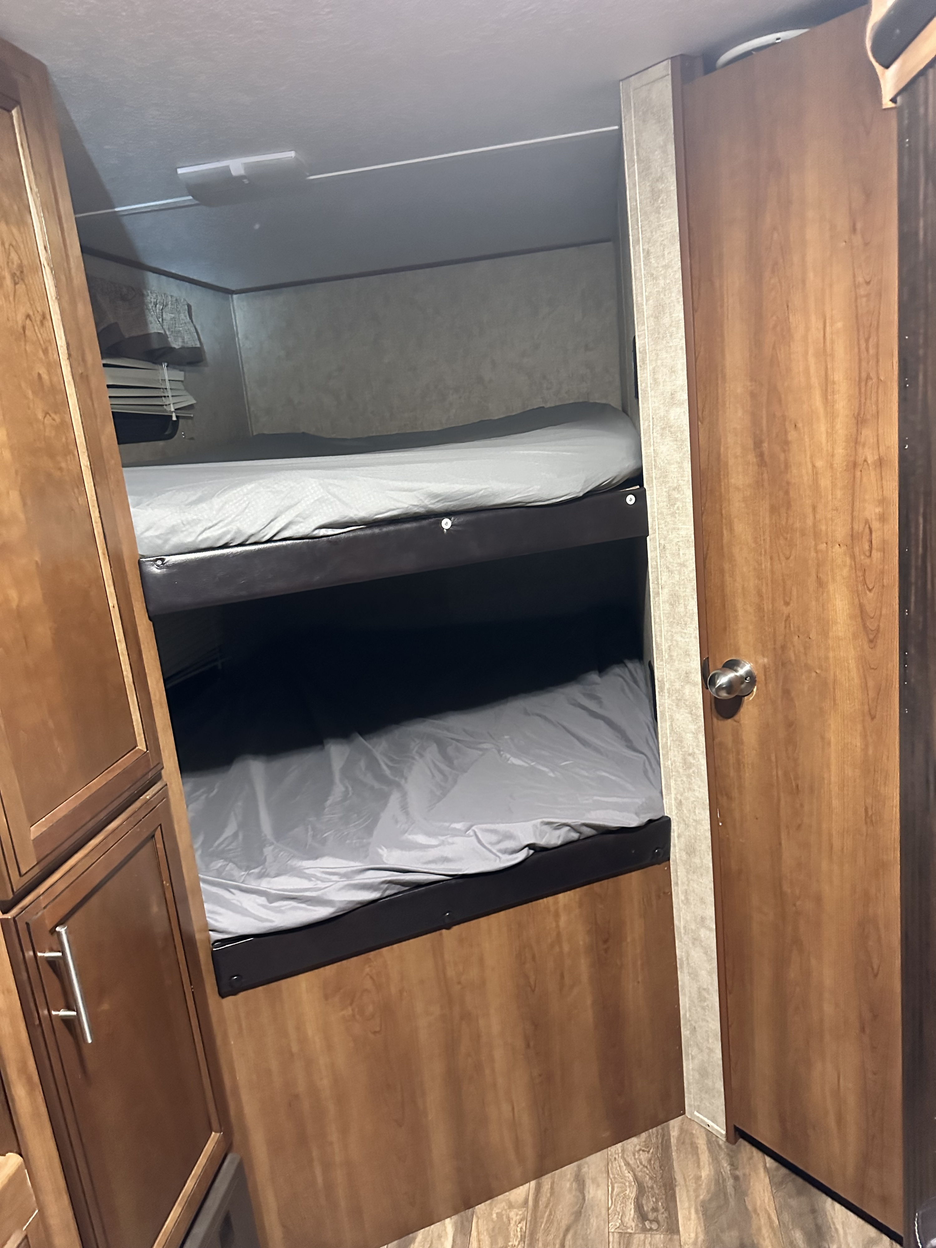 RV rental: view of a compact interior with comfortable bunk beds, grey sheets, and warm wood cabinetry/door.. Avenger ATI 2018