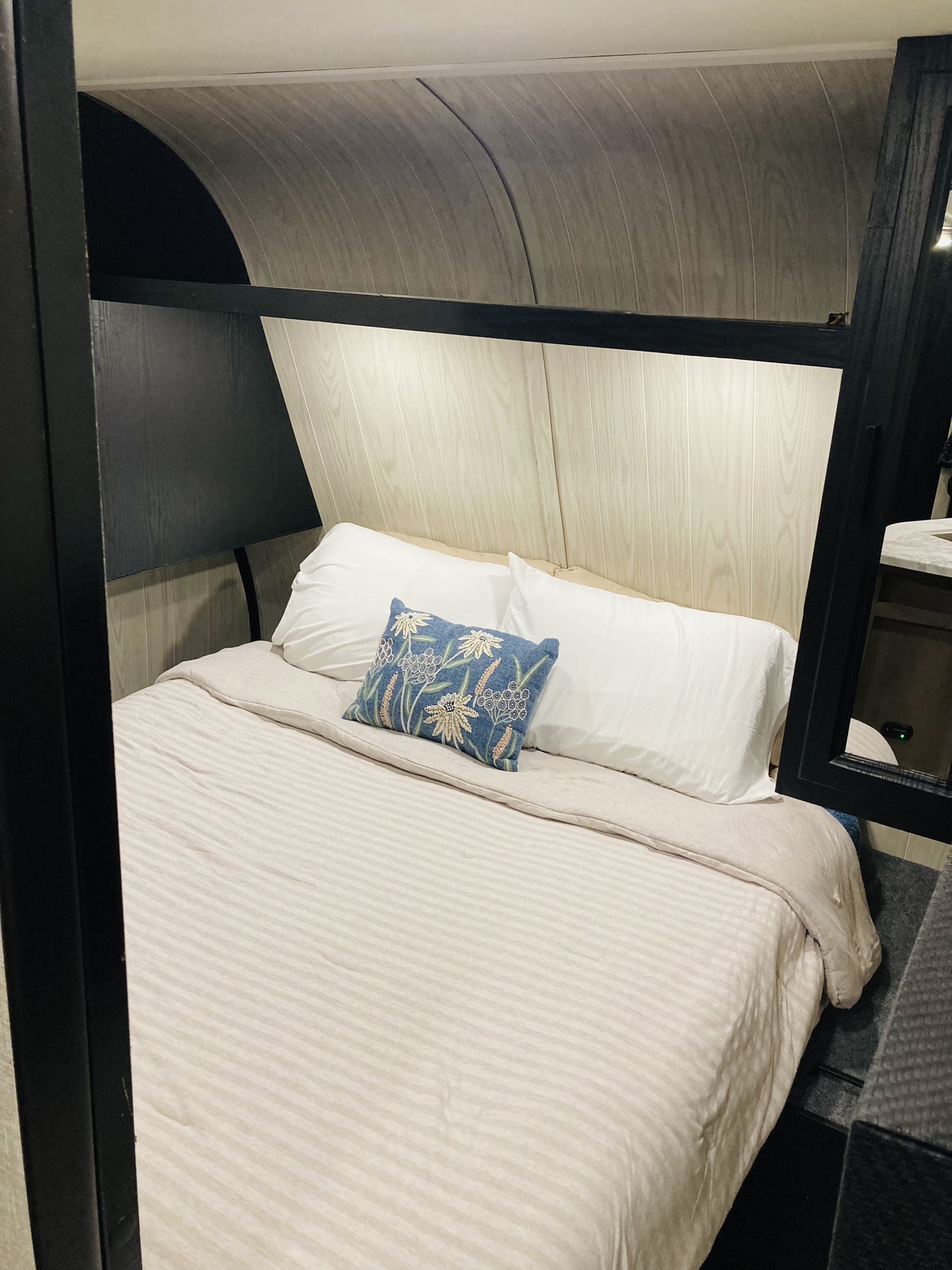 Cozy RV rental bedroom featuring a comfy bed with white pillows and a blue accent pillow. Modern and well-lit for your travels.. Jayco Jay Flight SLX Rocky Mountain Edition 2022
