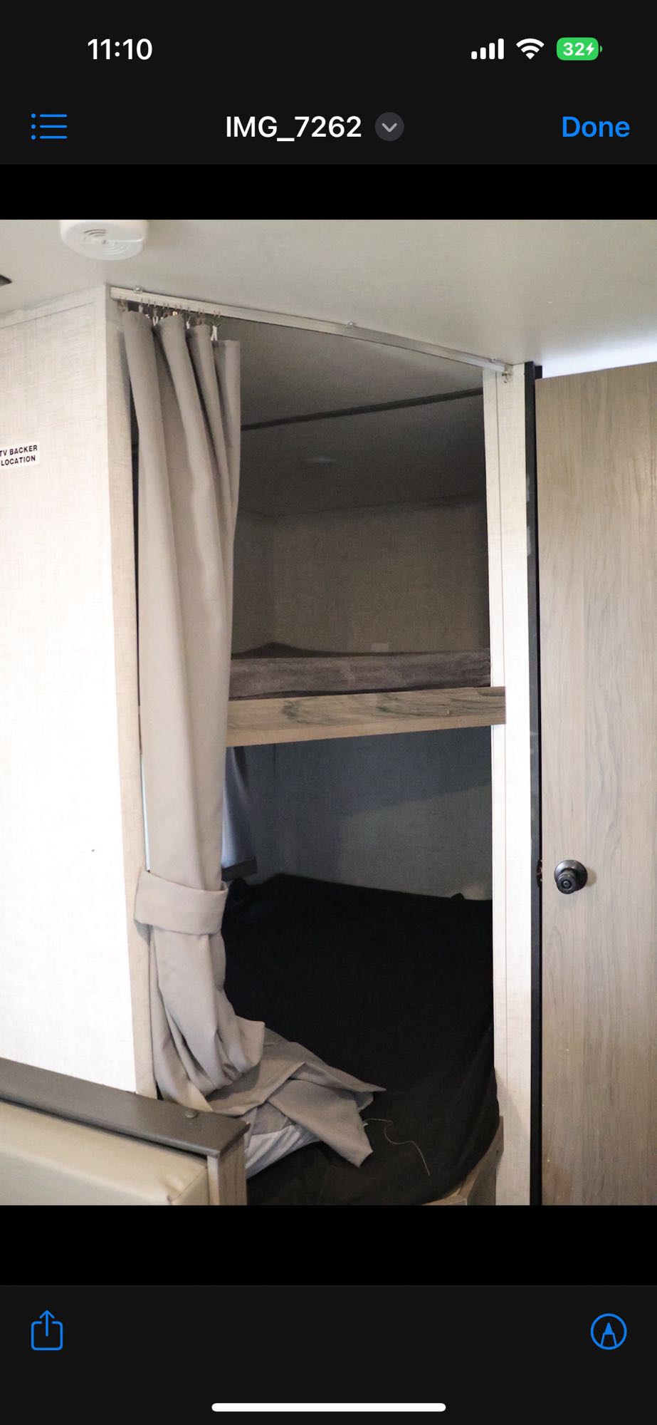 RV rental: Interior view of bunk beds with a tied-back curtain, showing mattresses in a cozy space.. Gulf Stream Enlighten 2022