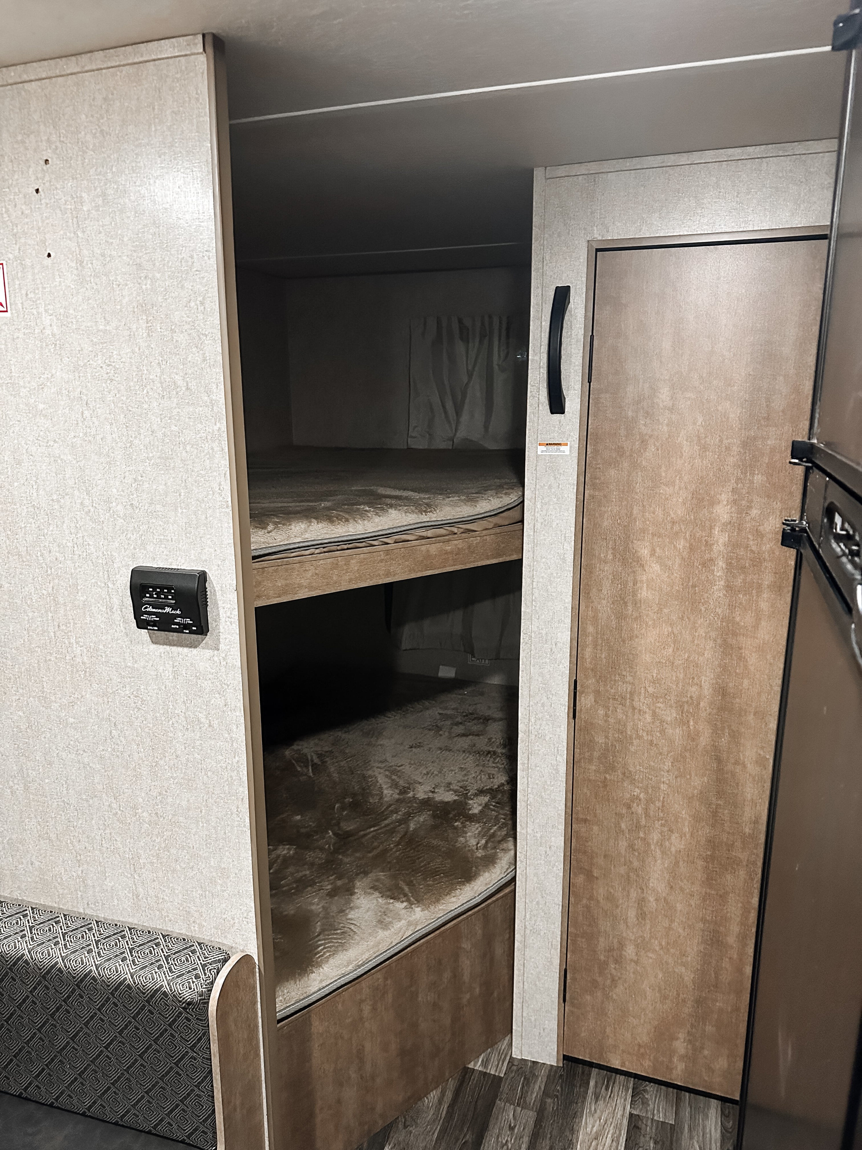 Cozy RV rental interior featuring bunk beds, a thermostat, and part of a fridge, perfect for camping travel.. Starcraft AR-One Maxx 2017