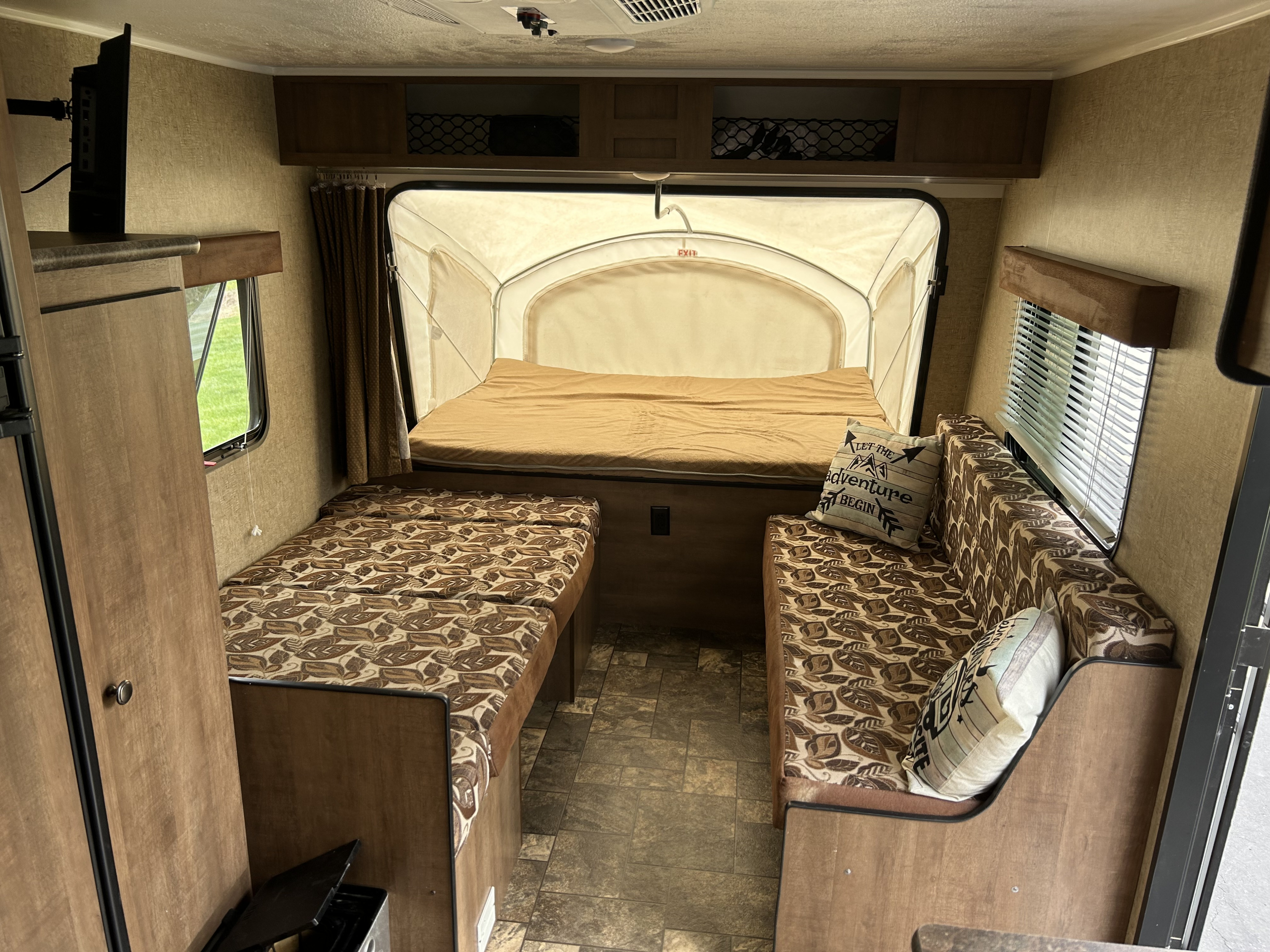 RV rental interior: large pop-out bed, two bench beds, TV, and overhead cabinets.. KZ SPORTSMEN 2017