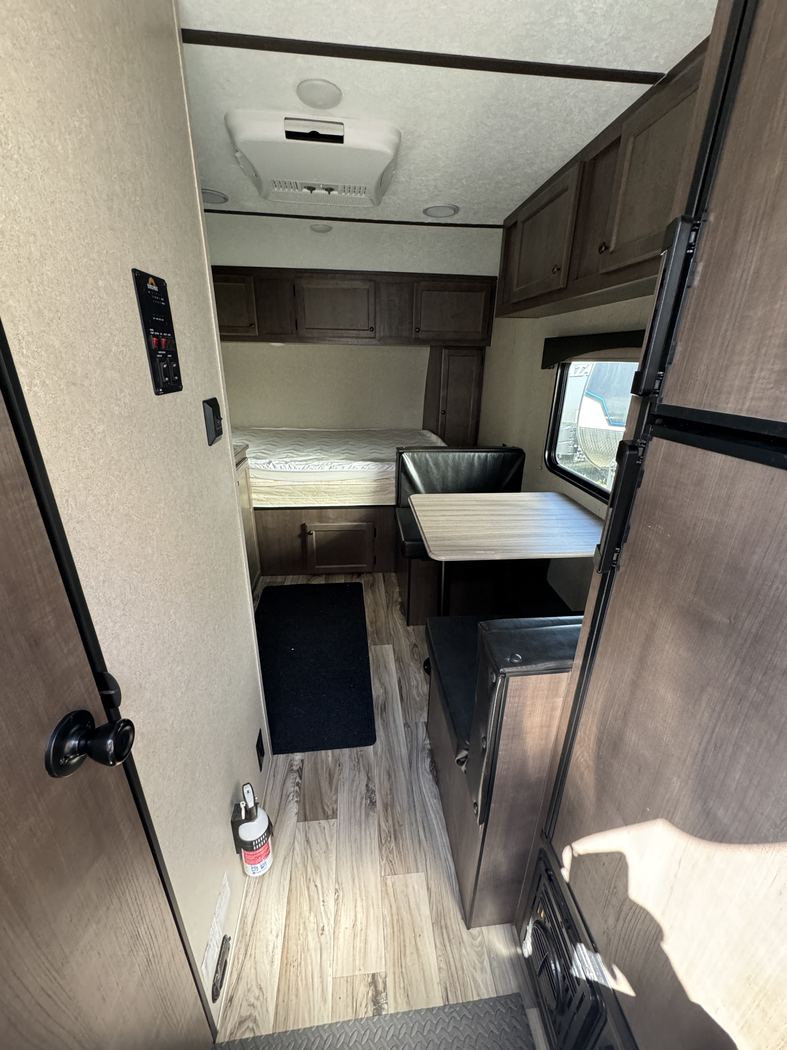 Explore this RV rental's interior: compact bed area, dinette, control panel, and refrigerator. Ideal for road trips.. Sun Lite 16BH Classic 2021