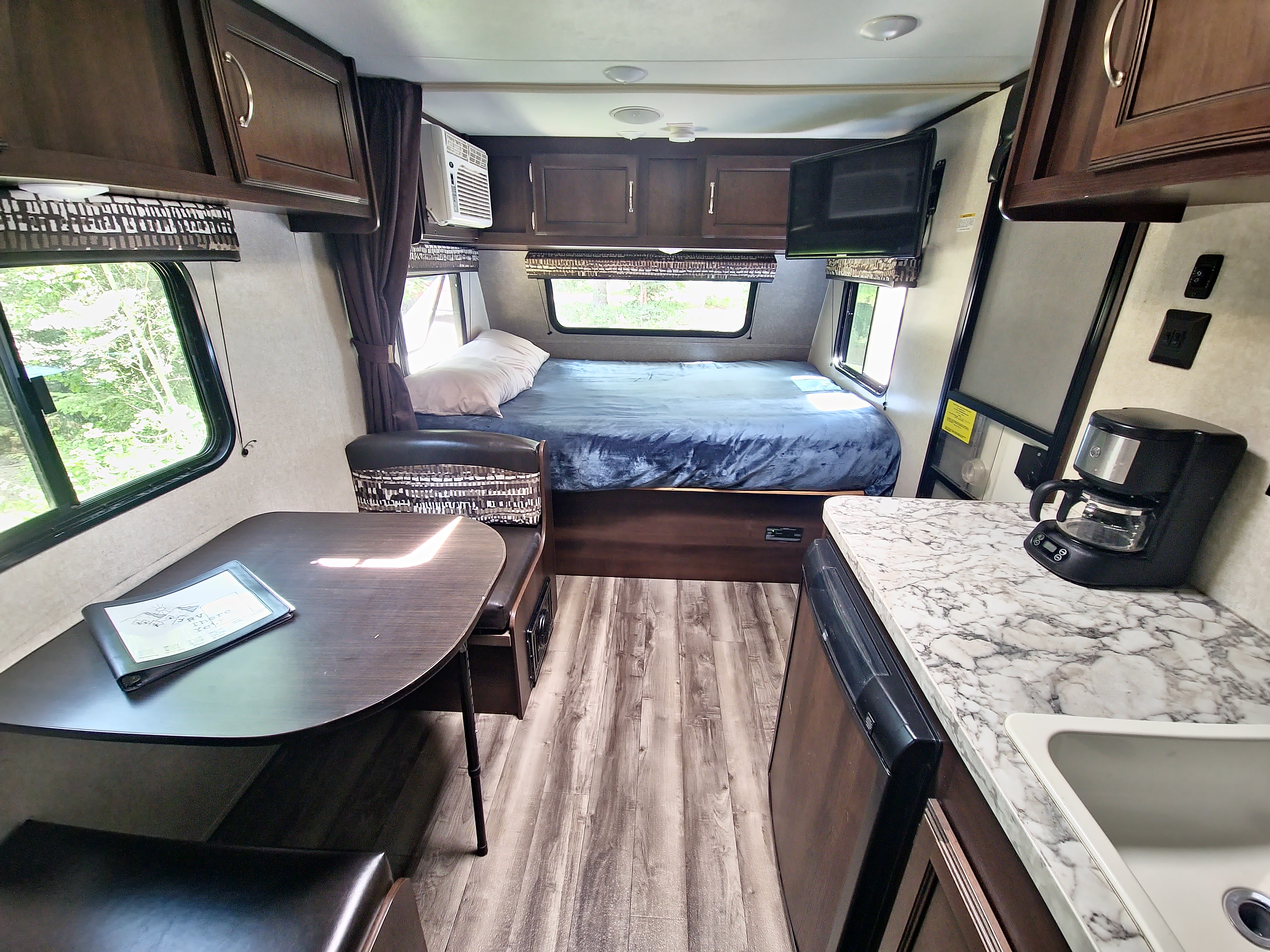 This RV rental interior features a cozy dinette, comfortable bed, and compact kitchen space.. Jayco Jay Flight SLX 2018