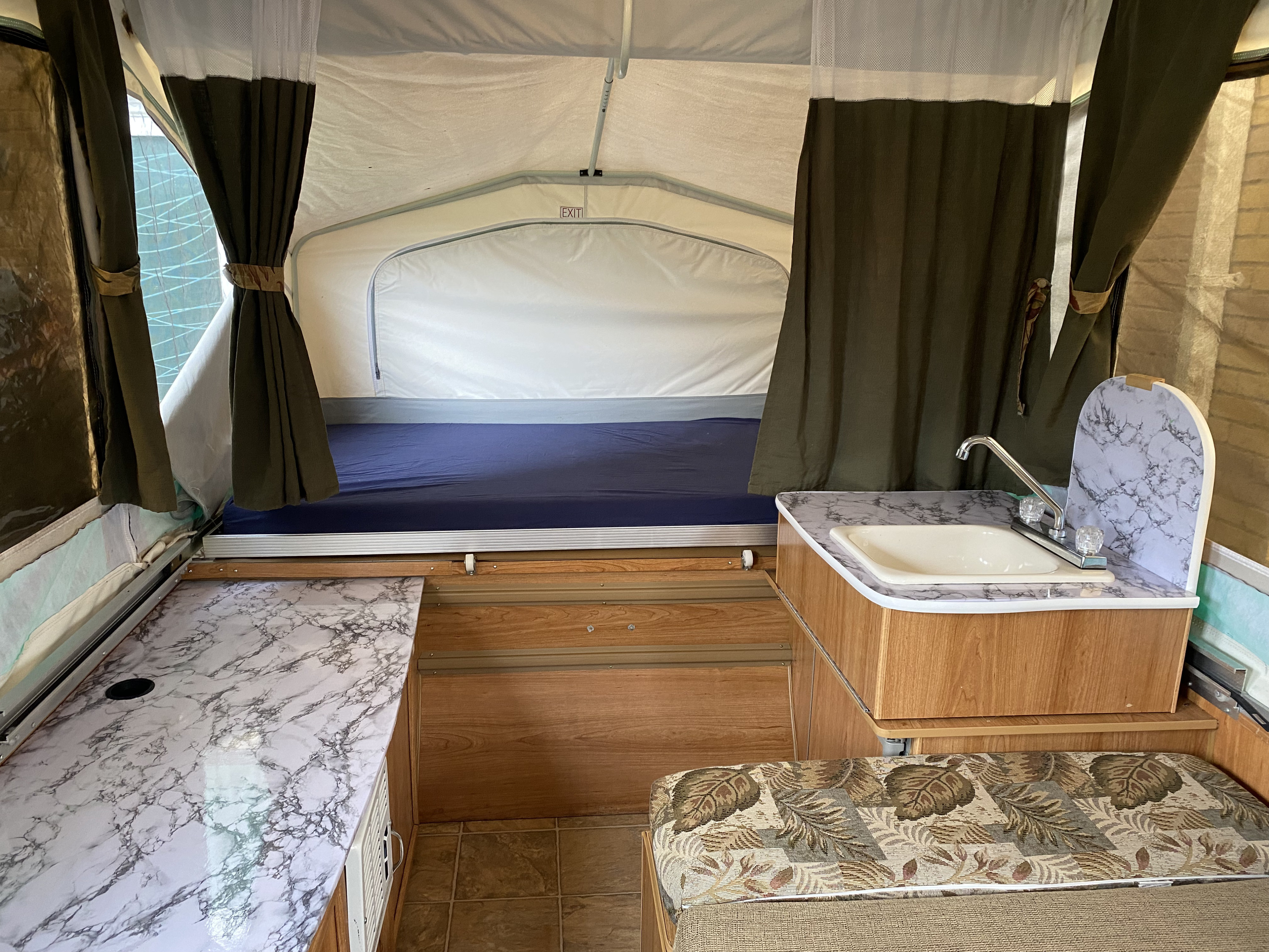 Cozy pop-up RV rental interior with kitchen, sink, and bed, perfect for your next camping adventure.. Palomino Real - Lite 801 2007