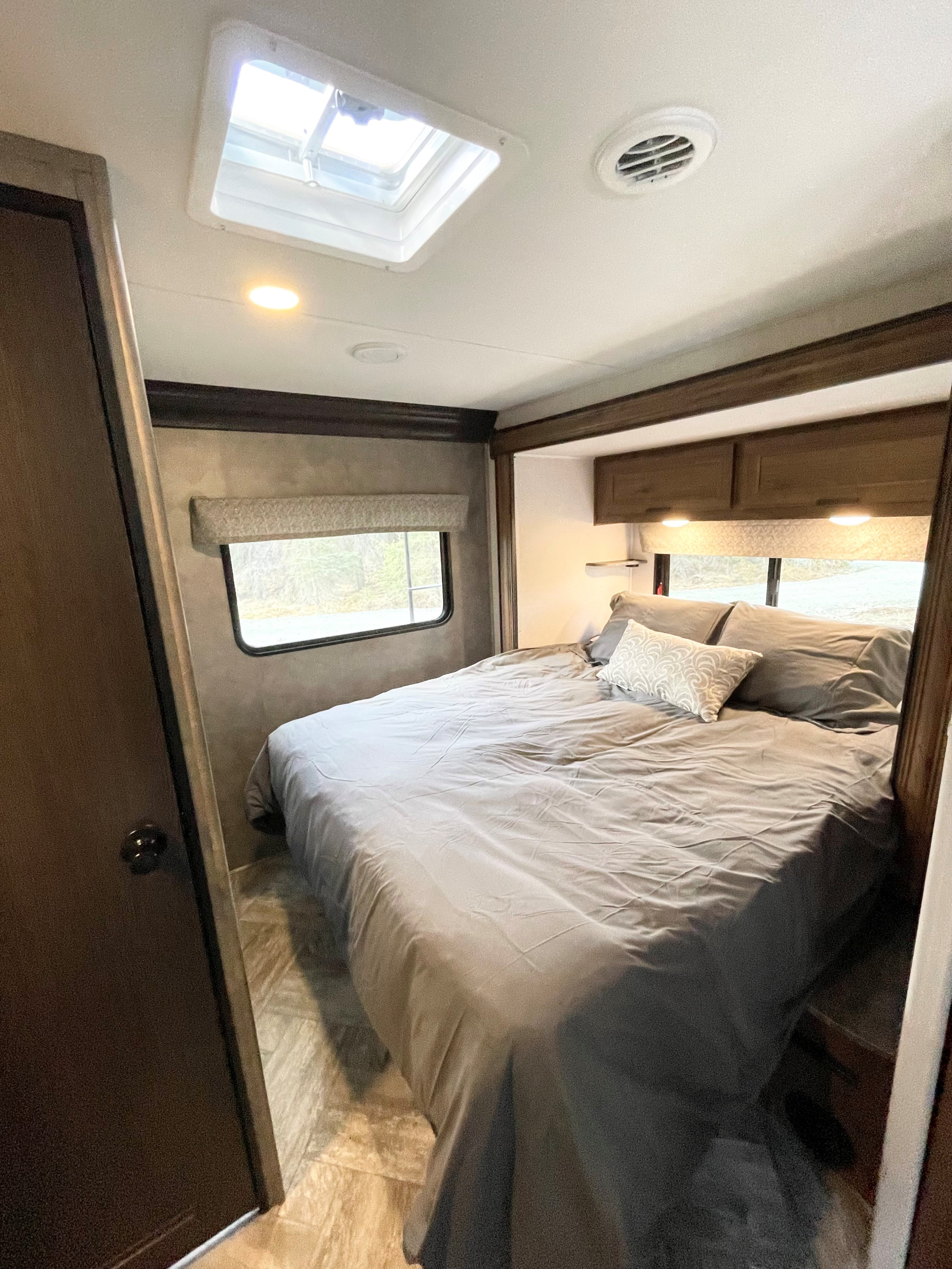 Step into this comfortable RV rental bedroom, featuring a large bed, skylight, and overhead storage for a cozy travel experience.. Forester LE 2022