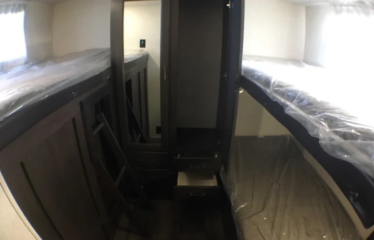 RV rental bunk beds: sleeping area with protective covers, central storage, and ladder.. Forest River Salem Cruise Lite 2020