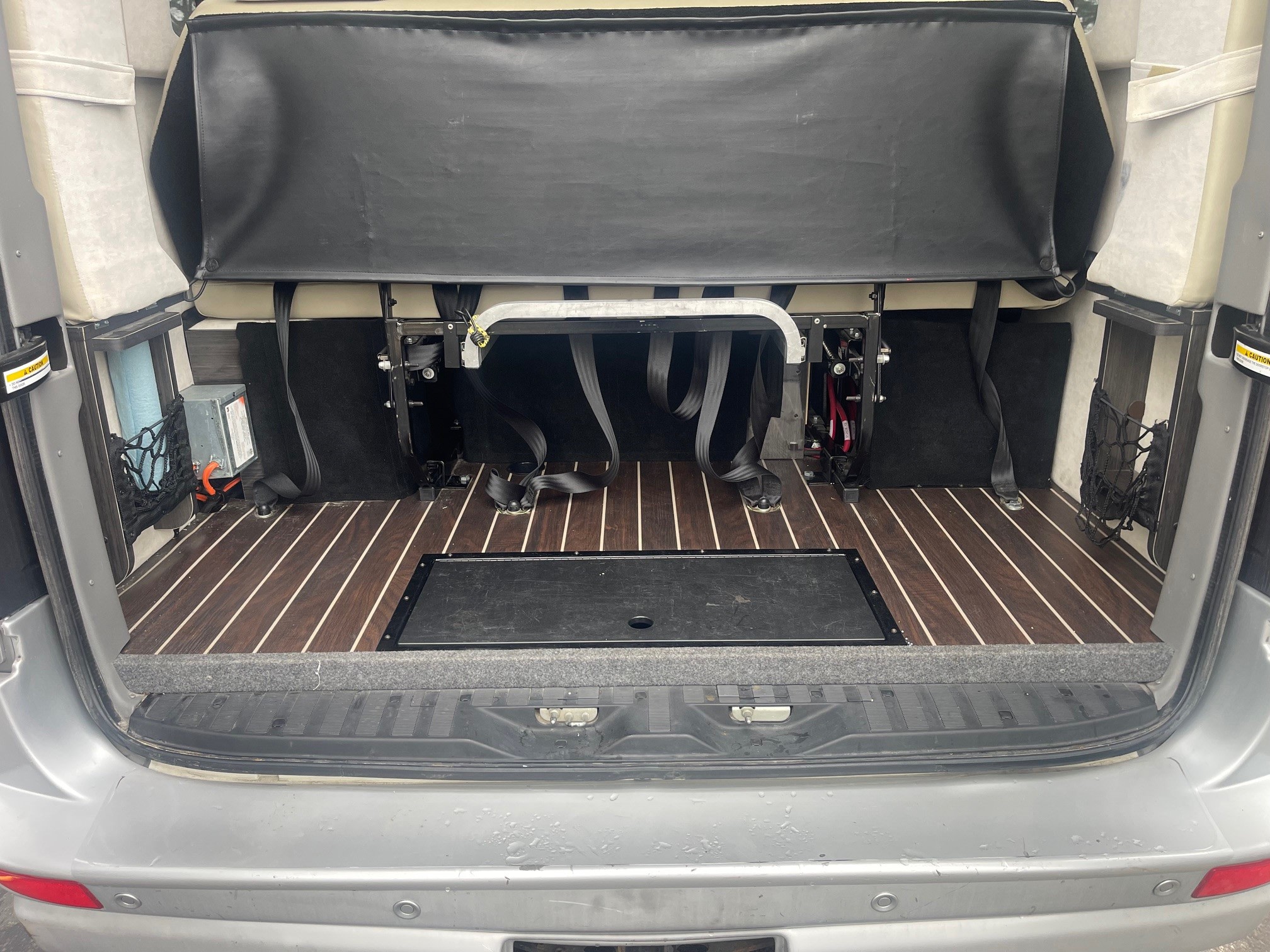 RV rental rear interior: versatile cargo space with wood floor, seatbelts, and black divider. Ready for adventure!. Airstream Interstate 2014