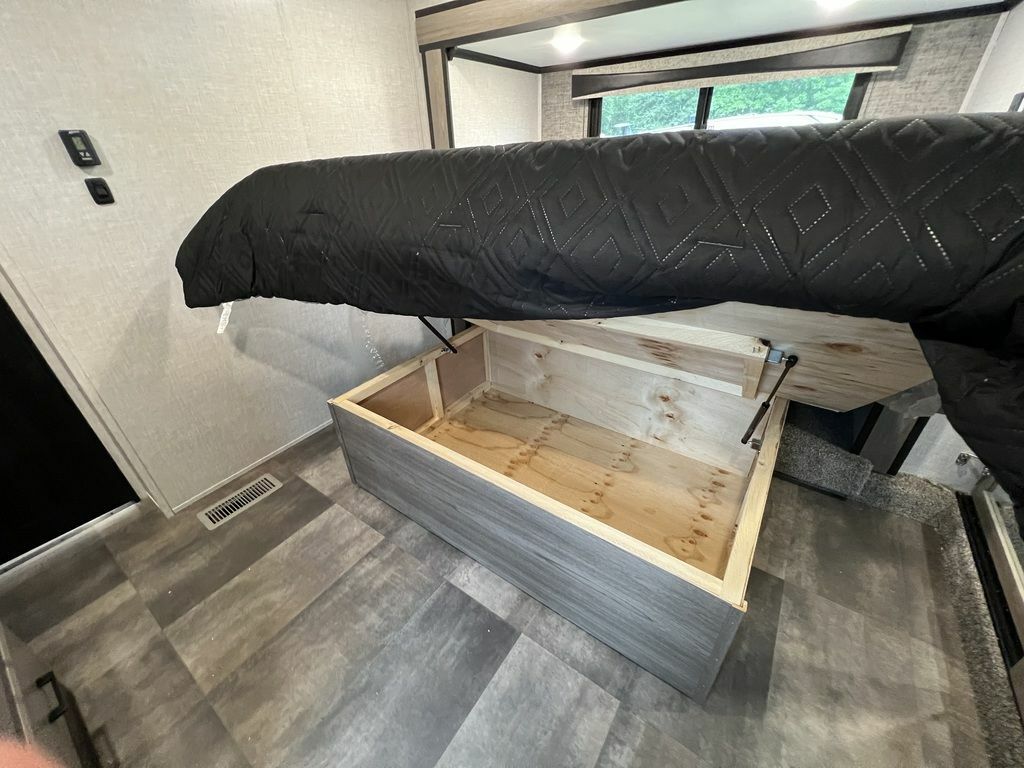 RV rental: Bed lifted by gas struts reveals spacious under-bed storage, a smart solution for optimizing space.. Crossroads Cameo 2021