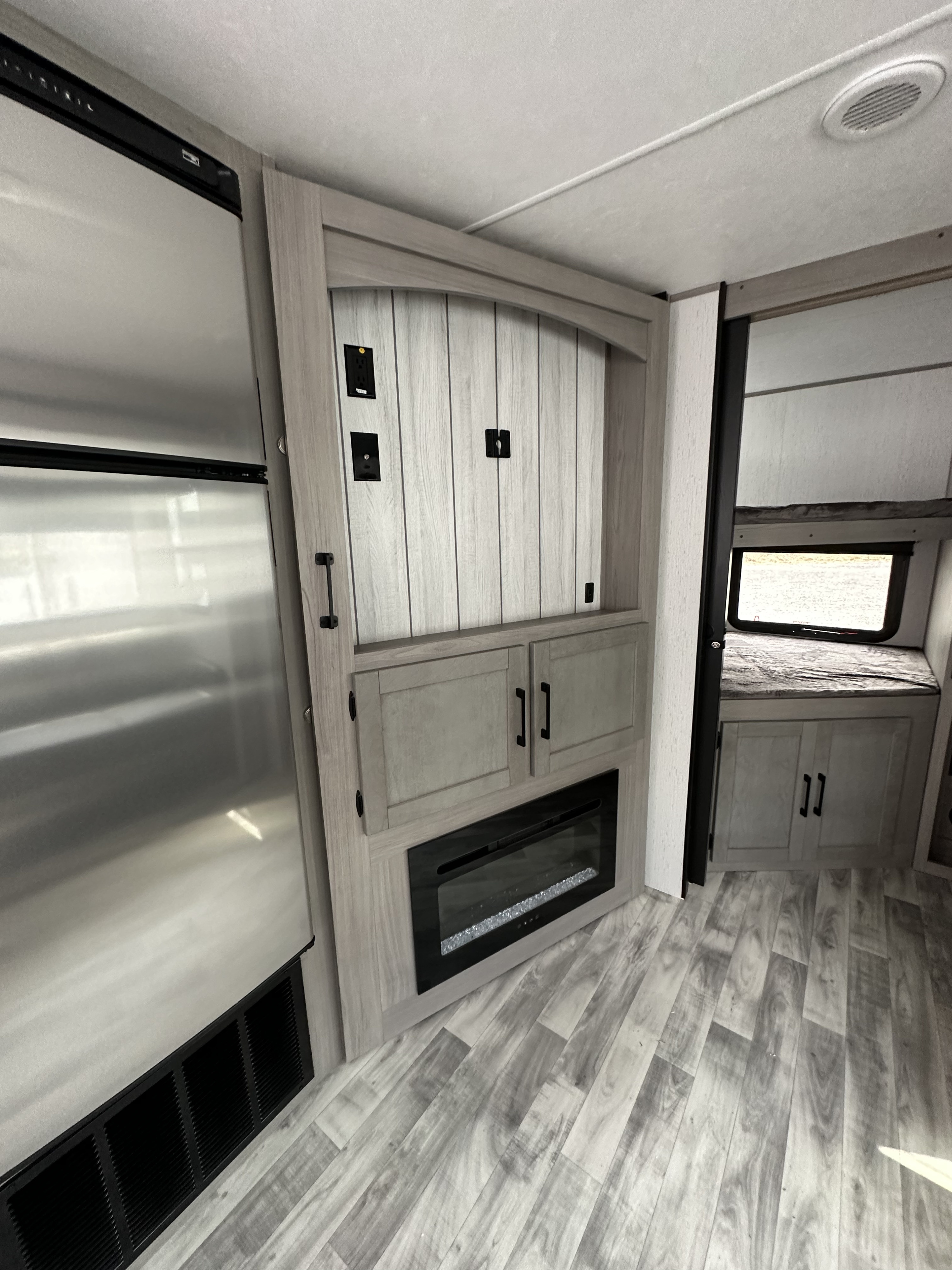 RV rental showcasing a large stainless steel refrigerator, modern entertainment center with fireplace, and a comfortable bunk area.. Dutchmen Kodiak Ultra Lite 2022