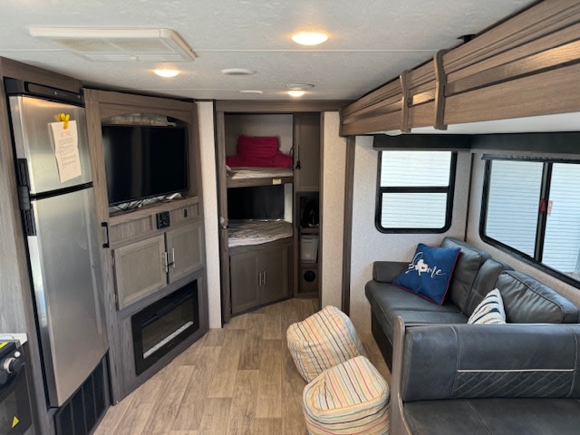 Spacious RV rental interior with a living area, kitchen, entertainment center, and bunk beds for family travel.. Dutchmen Kodiak Ultra Lite 2021