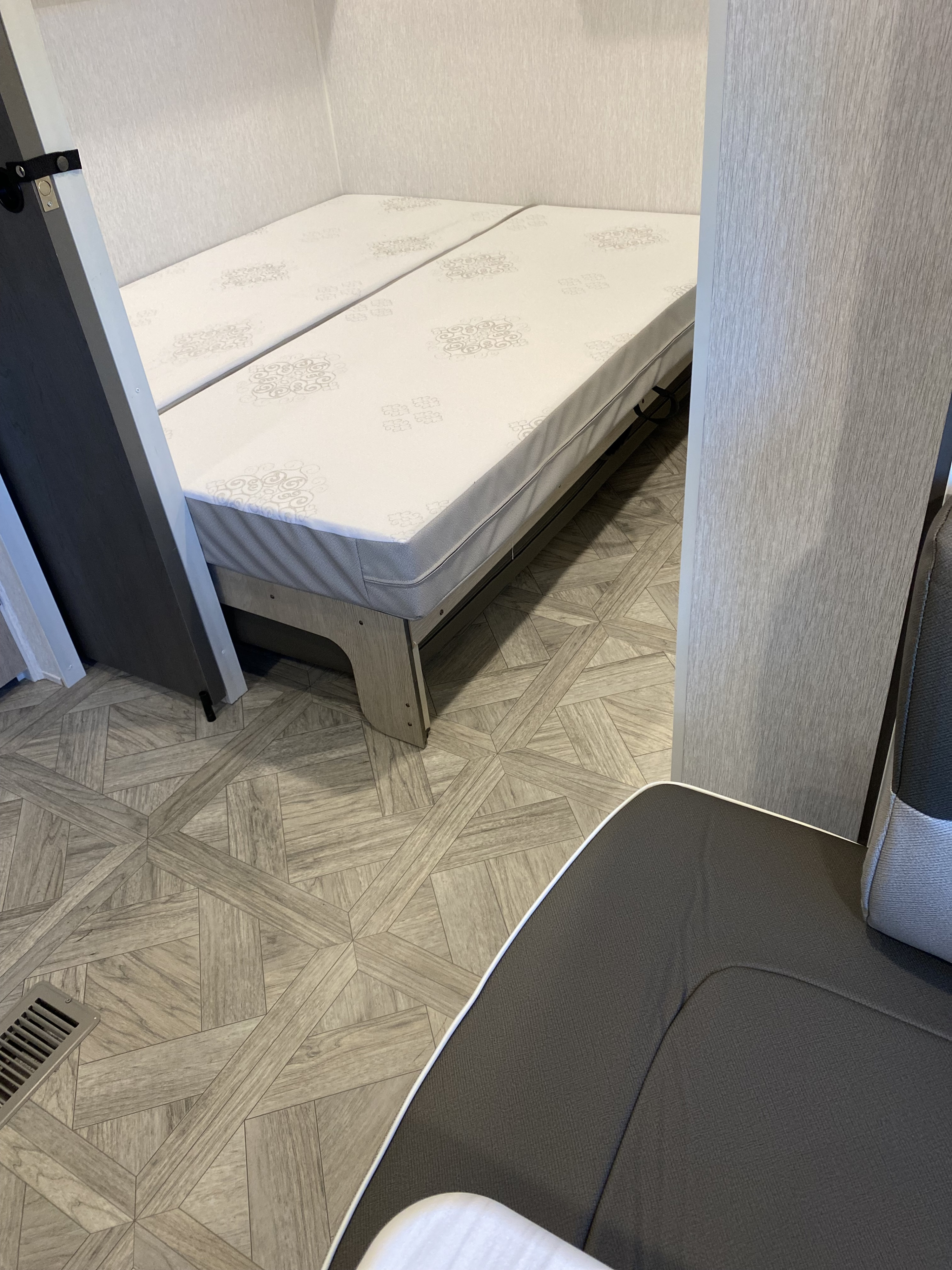 RV rental: Bright camper interior featuring twin beds, wood-look flooring, and textured wall panels.. Forest River Salem 2024