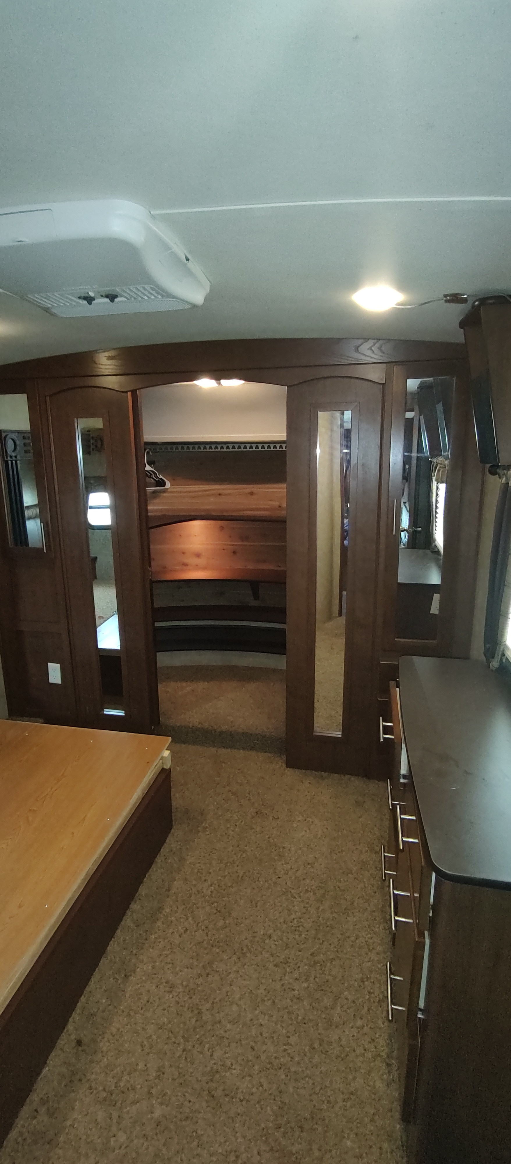 Cozy RV rental interior with a partitioned bunk bed area, overhead AC, and dark wood cabinetry. Ideal for travel.. Dutchmen Komfort 3530fbh 2012