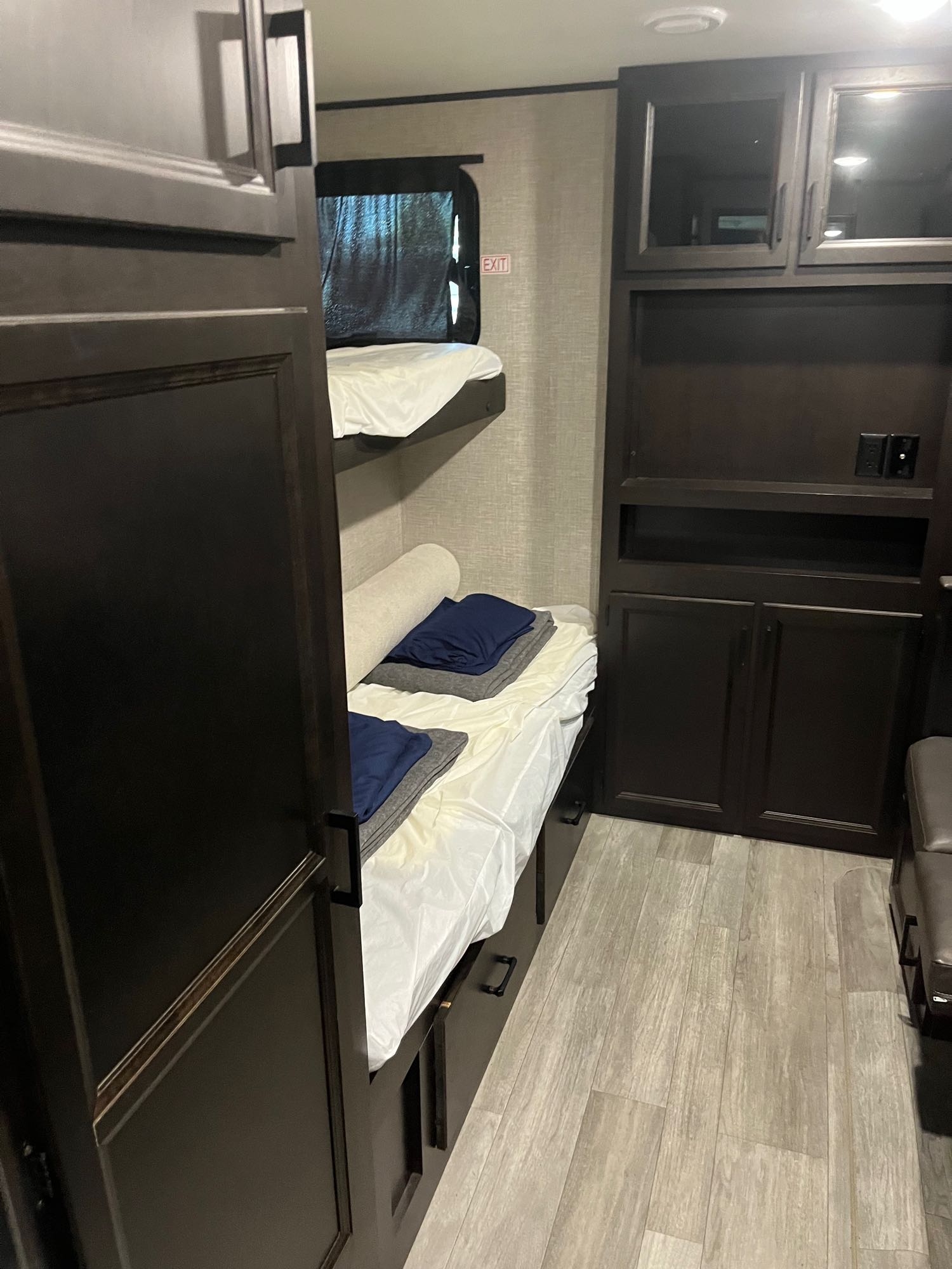 Explore the interior of this rv rental, featuring bunk beds, ample storage, and modern dark wood cabinetry.. Jayco Jay Flight 2022