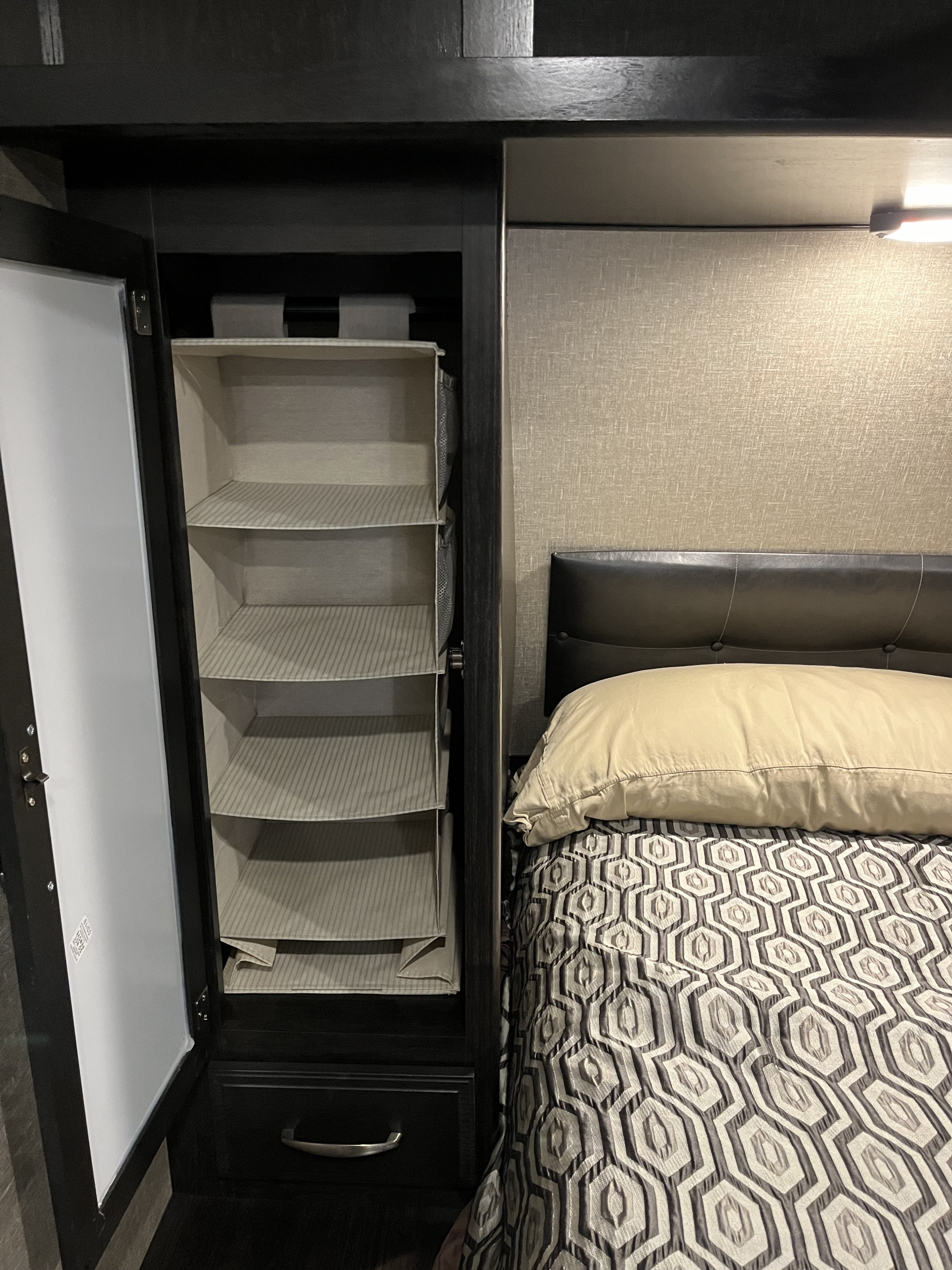 RV rental bedroom: Organized multi-shelf closet and bed with geometric quilt.. Grand Design Imagine 2020