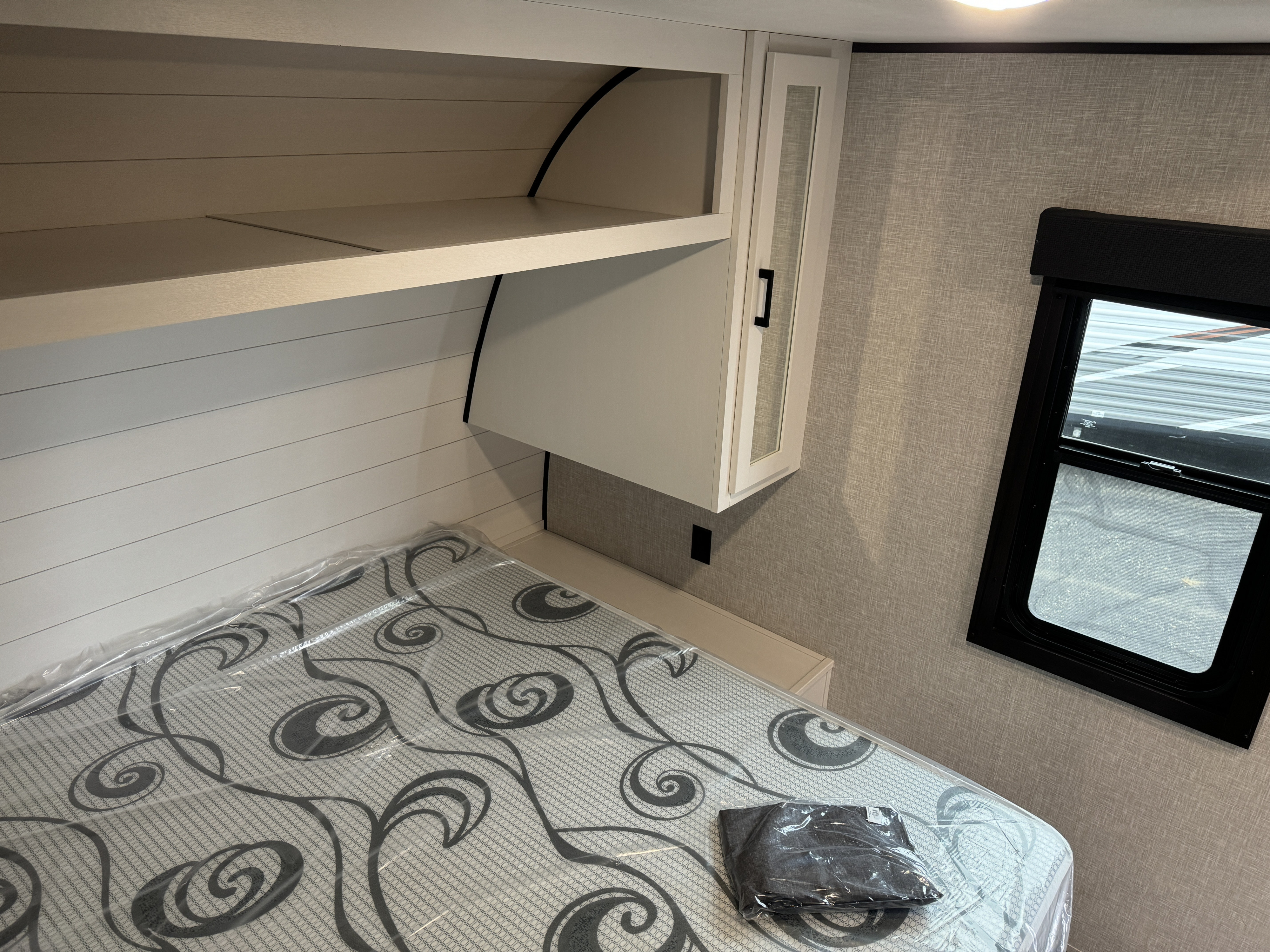 RV rental bedroom: new mattress, overhead shelves, & window. A clean, compact space for your next journey.. Starcraft Autumn Ridge 2024