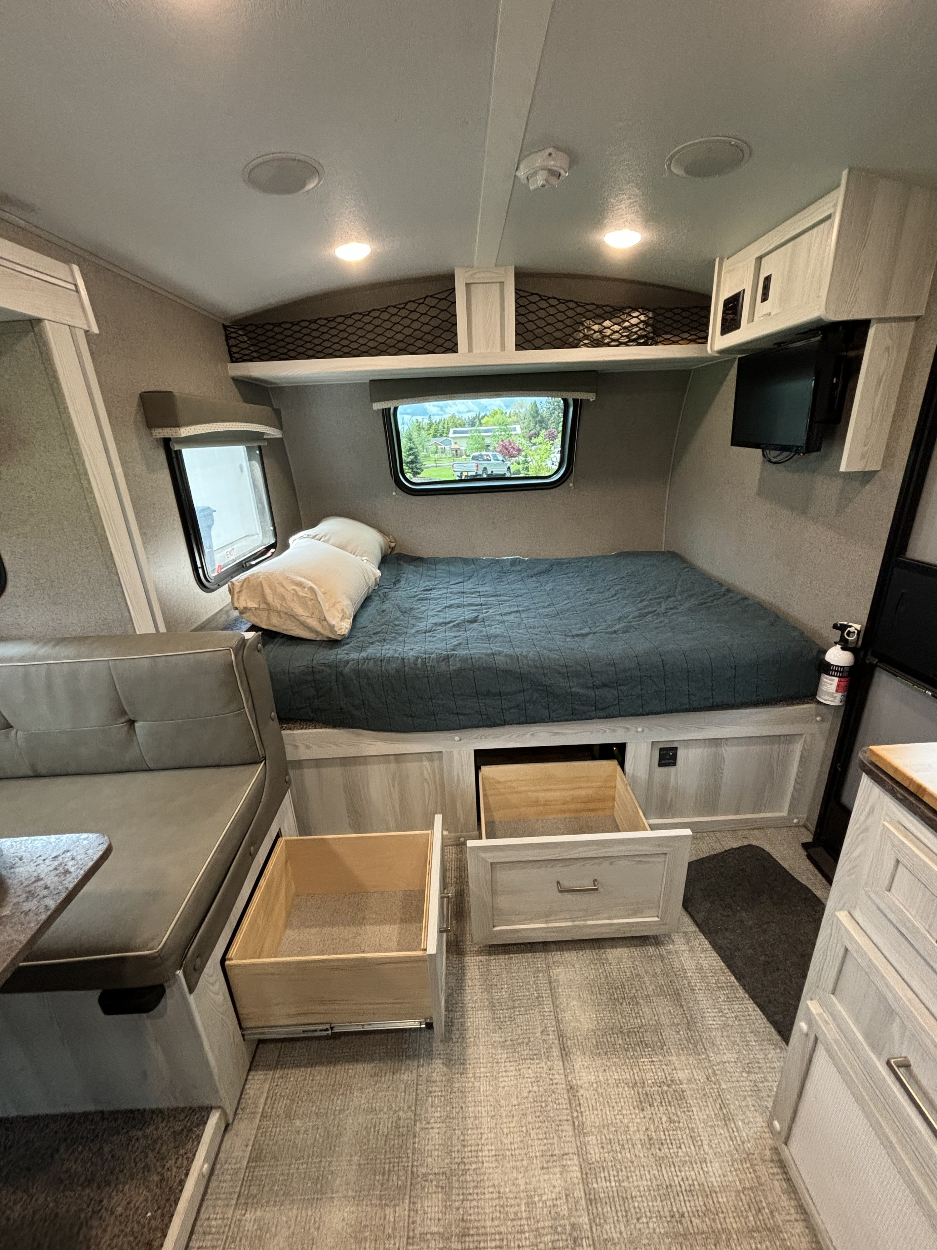 RV rental interior: compact bedroom with a bed, under-bed storage, a dinette, and overhead compartments.. Forest River Rockwood Geo Pro 2021