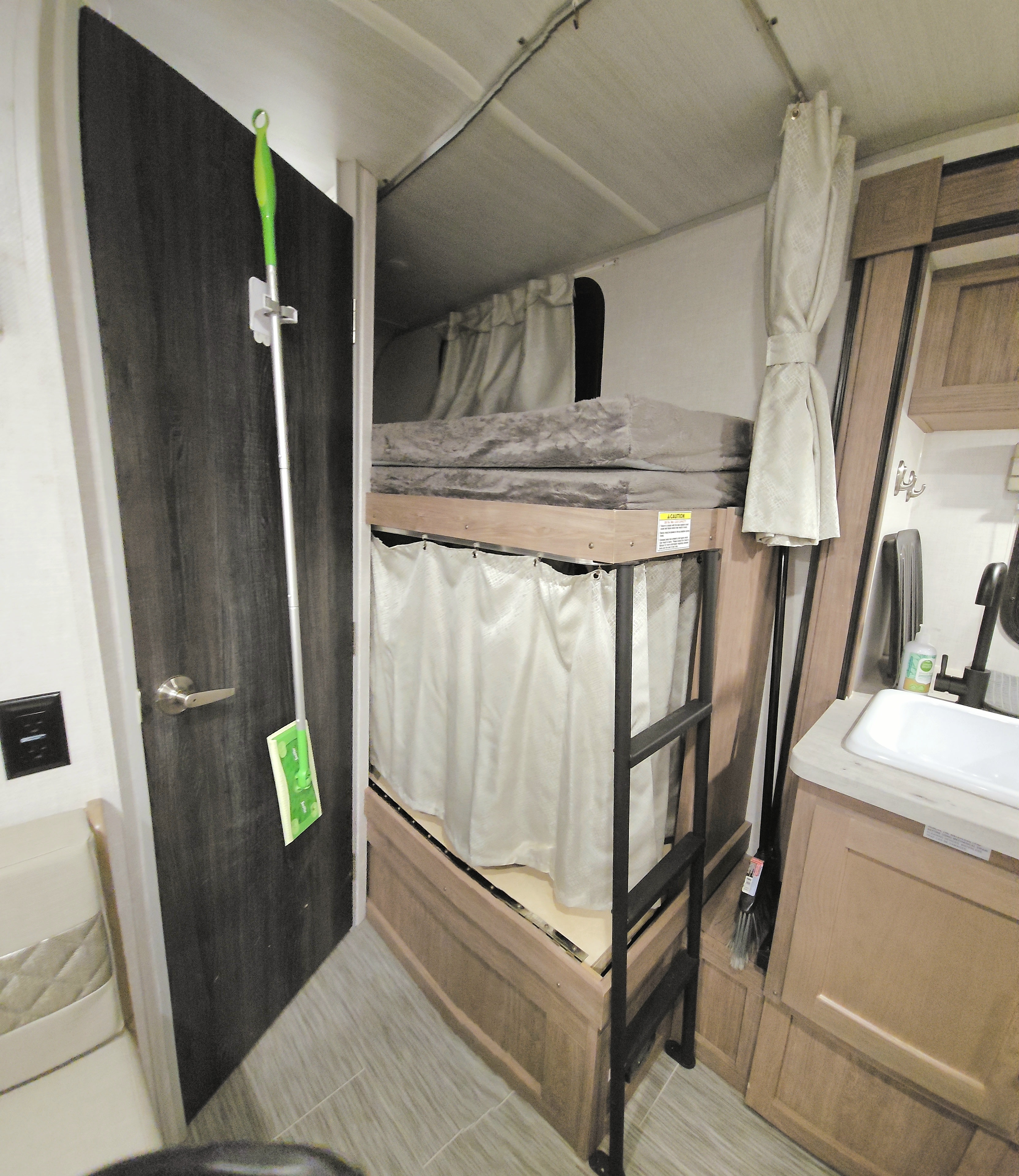 RV rental interior: bunk beds with privacy curtains and a compact sink area, perfect for travel.. No Boundaries 16.6 2021