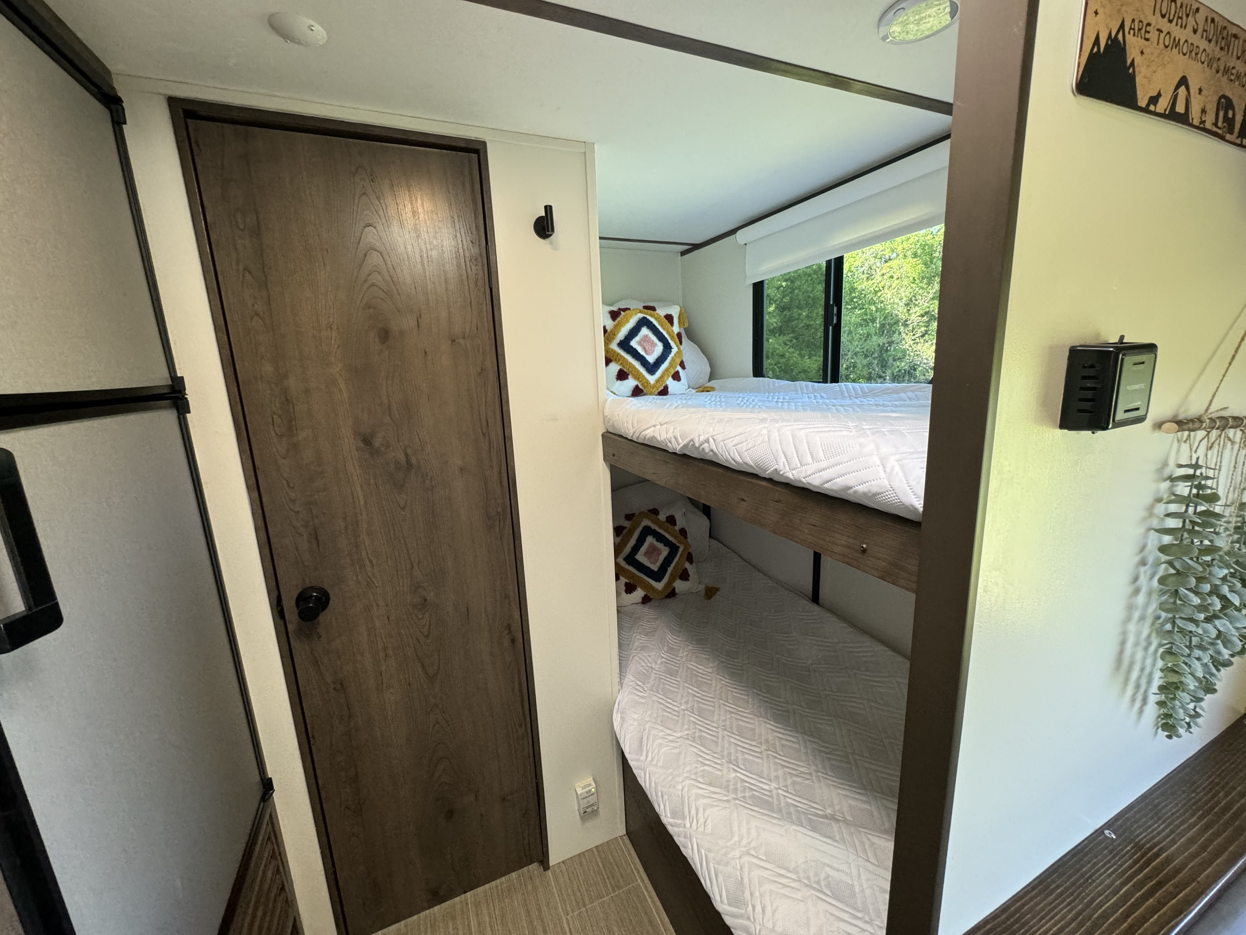 RV rental: Cozy bunk beds for a comfortable stay, with a scenic window view and nearby fridge.. Keystone RV Passport SL 2021