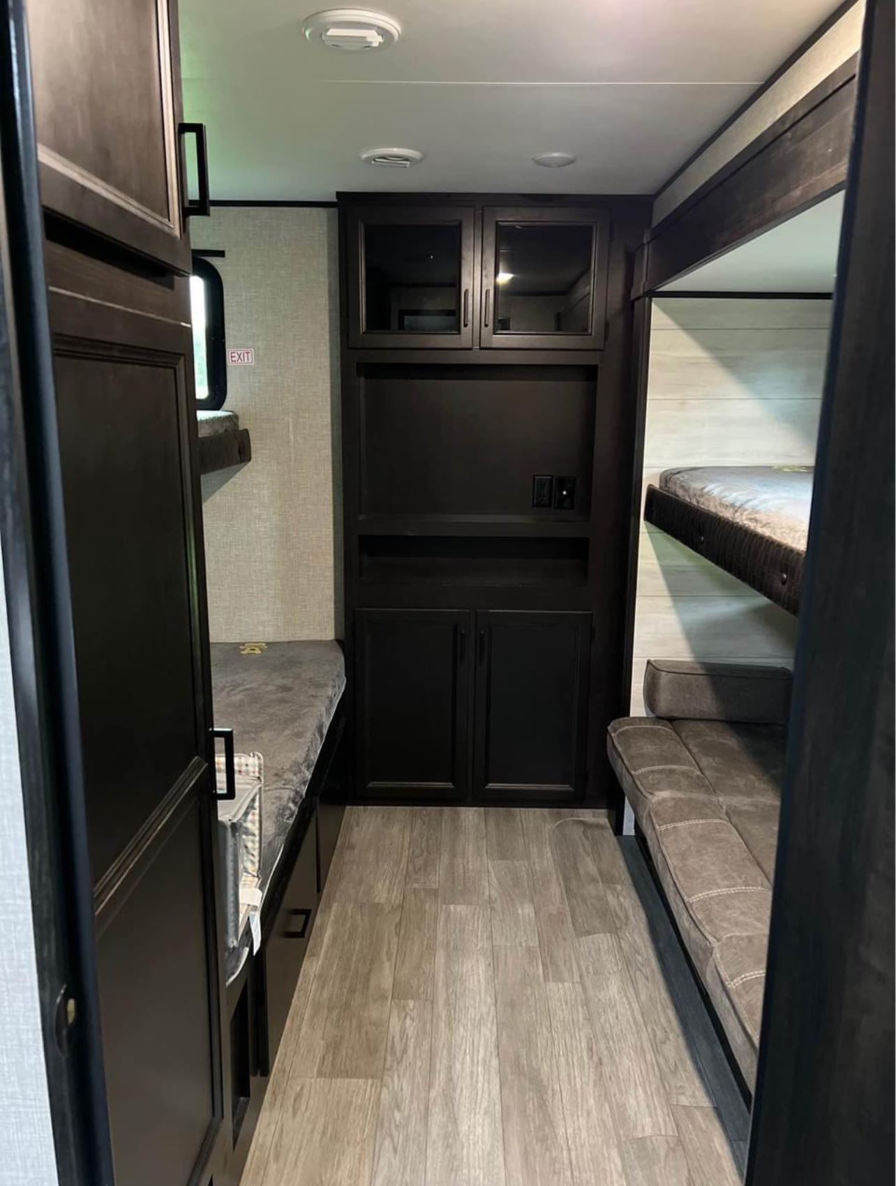 This RV rental features a cozy bunkhouse with multiple sleeping areas, including stacked bunks and a sofa, plus central storage.. Jayco Jay Flight 2021
