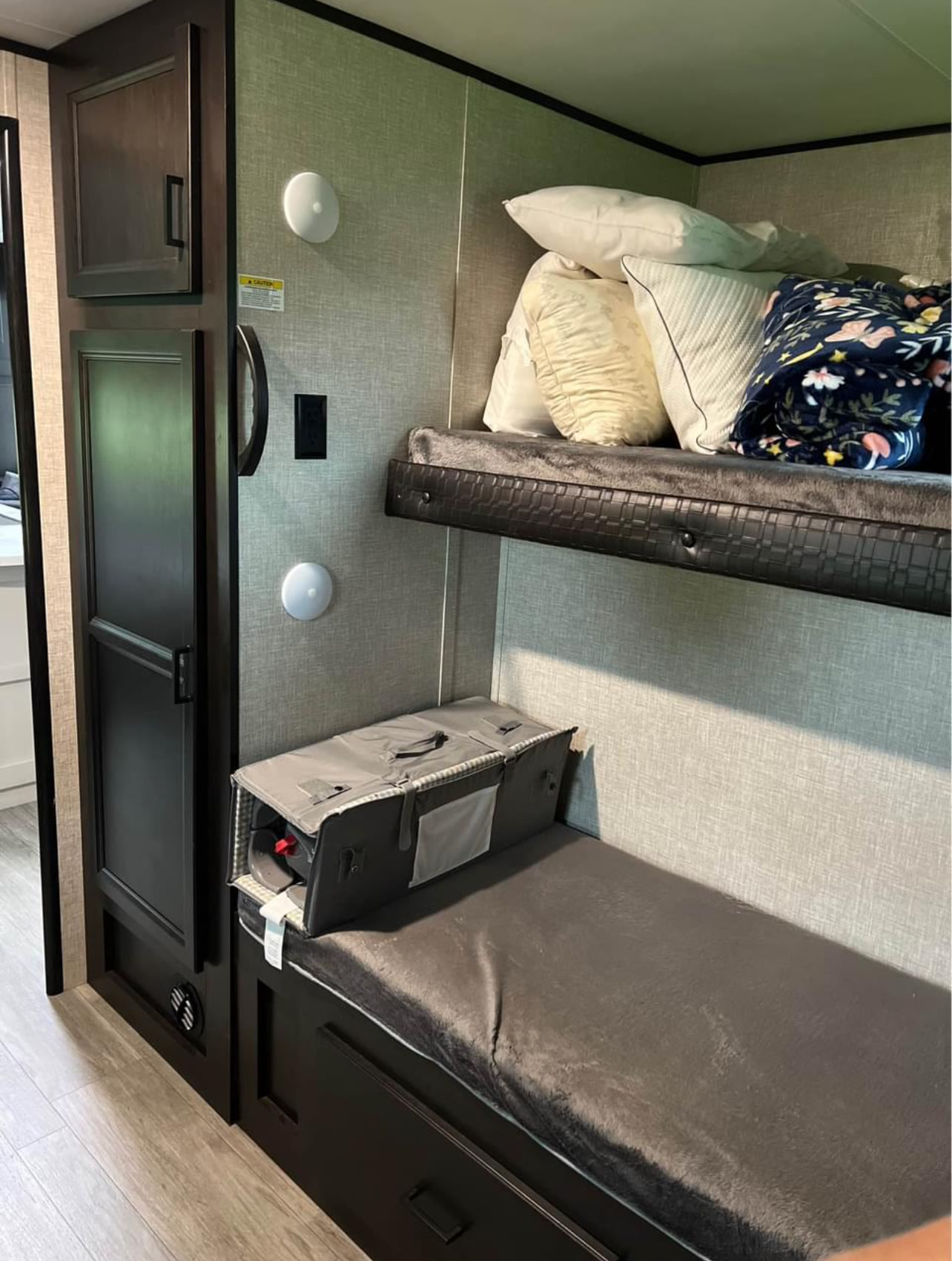 Explore this RV rental's interior: comfy bunk beds with bedding, a handy storage cabinet, and wall lights.. Jayco Jay Flight 2021