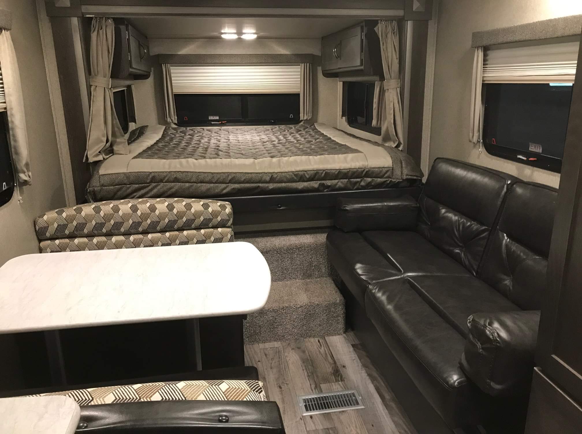 Experience comfort in this RV rental! Features a bed, dinette, and leather sofa within a cozy, functional interior.. Keystone RV Outback 210URS 2018