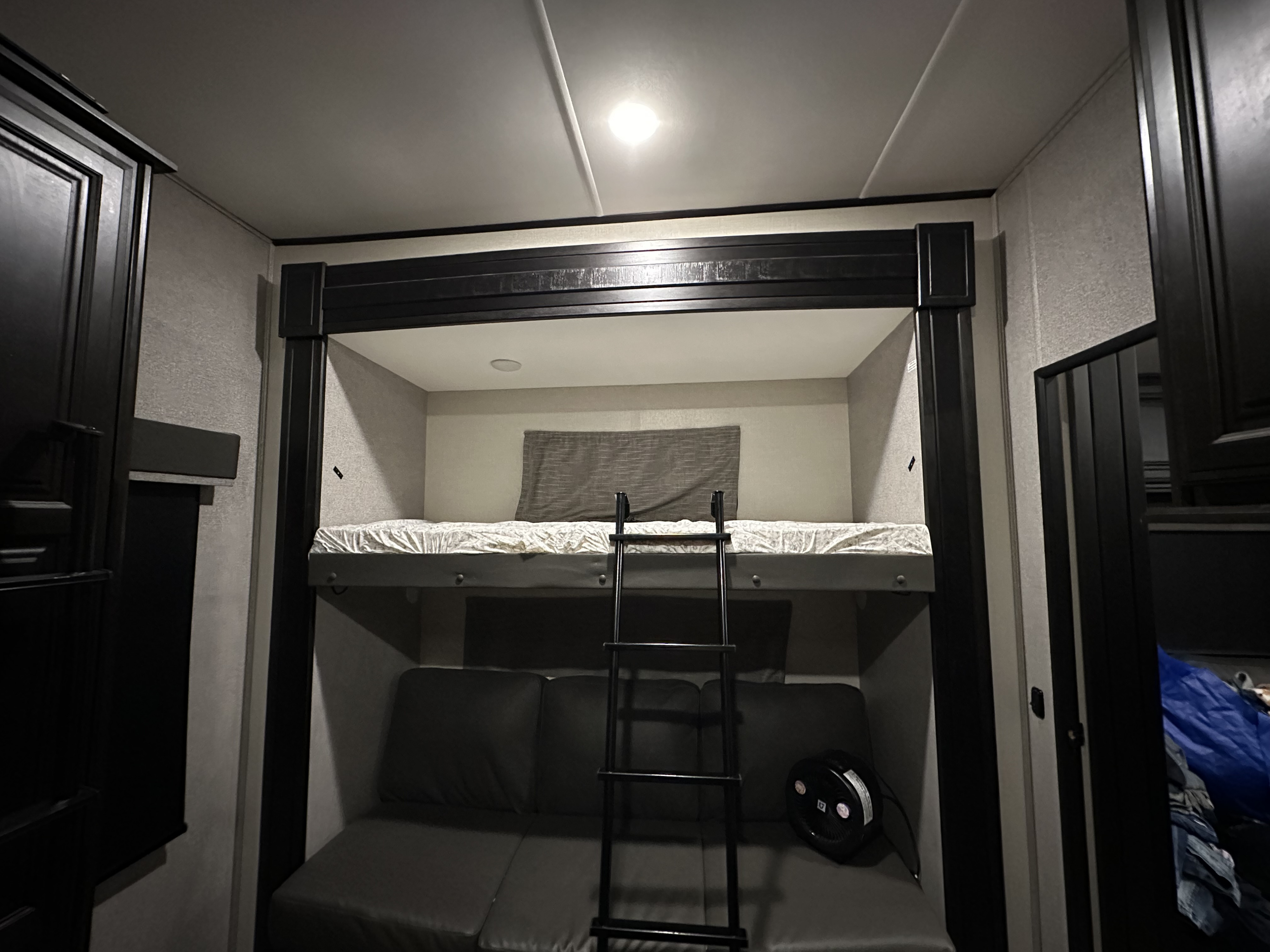 RV rental interior: Bunk beds with ladder, and a cozy sofa below, providing versatile sleeping and lounge space in a camper.. Highland Ridge RV Mesa Ridge XLT 2021