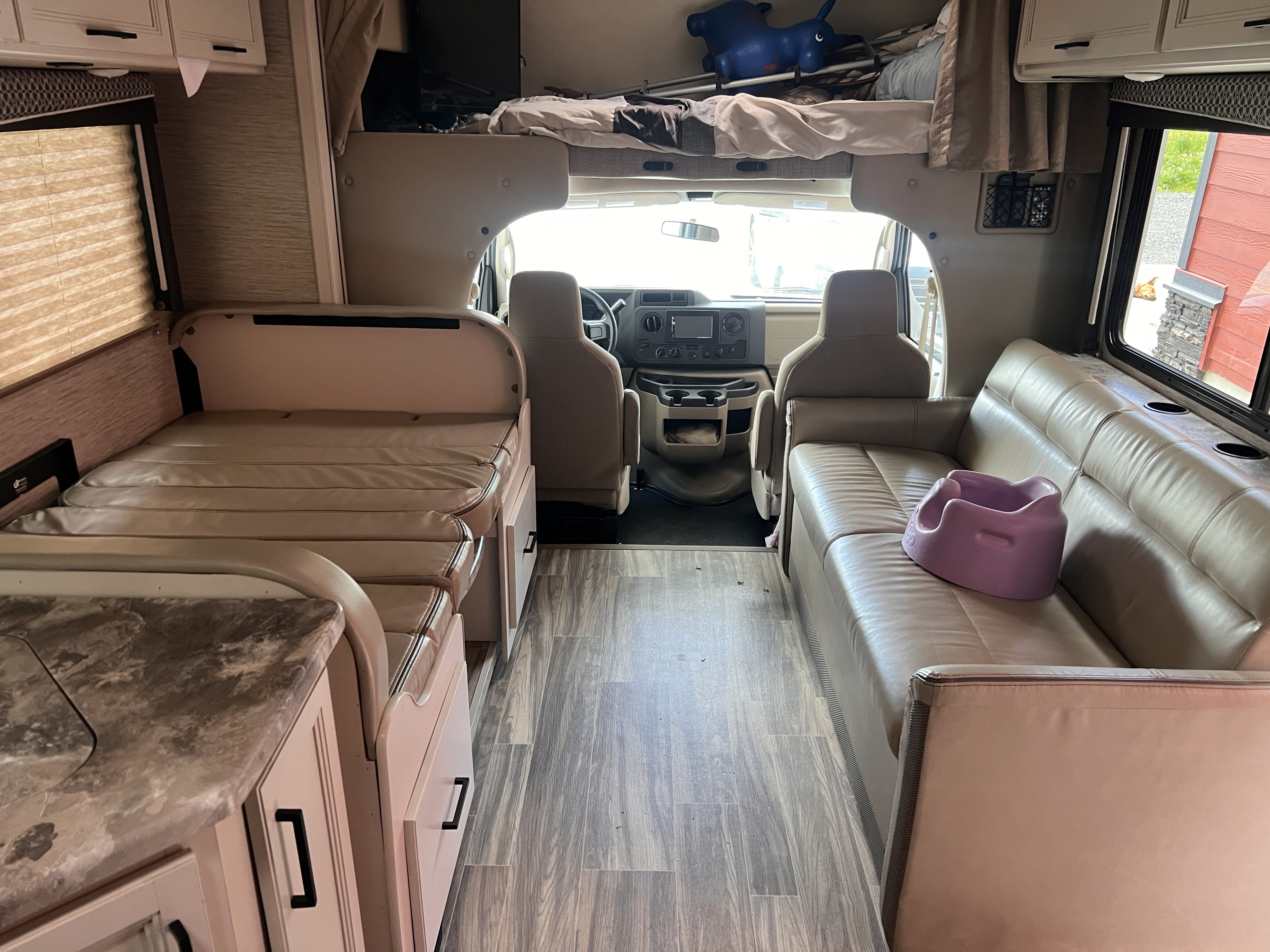 Spacious RV rental interior: bunk bed, convertible dinette, sofa with child seat, & driver's area.. Thor Chateau 2022