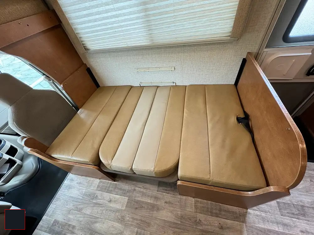 RV rental interior: A versatile tan-cushioned dinette with wood trim, converting to a comfortable bed for travelers.. Winnebago Minnie Winnie 2017