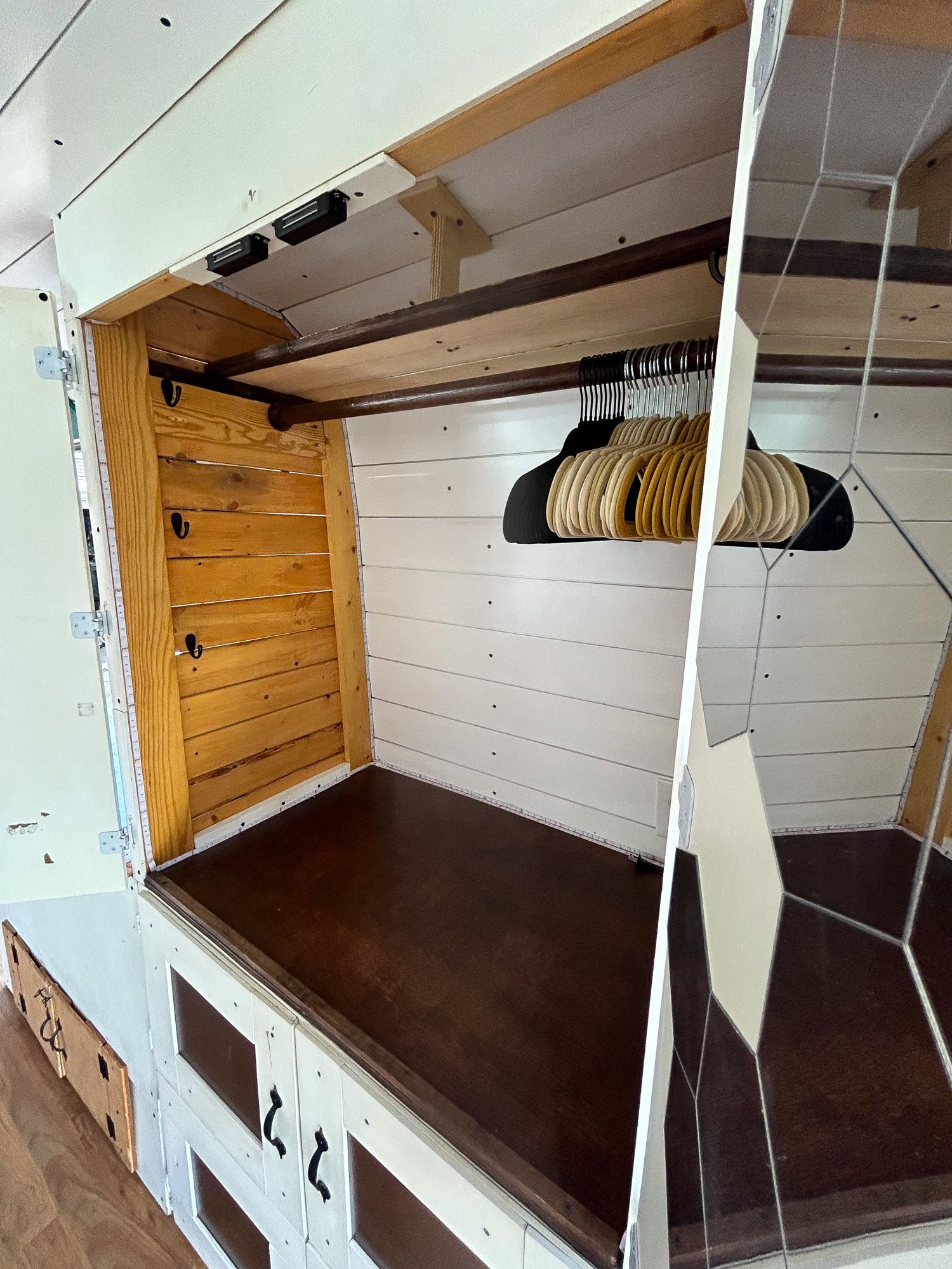 An RV rental's clever built-in closet features a hanging rod, hooks, & lower cabinets for compact clothing storage.. Ram Dodge Promaster 3500 2019
