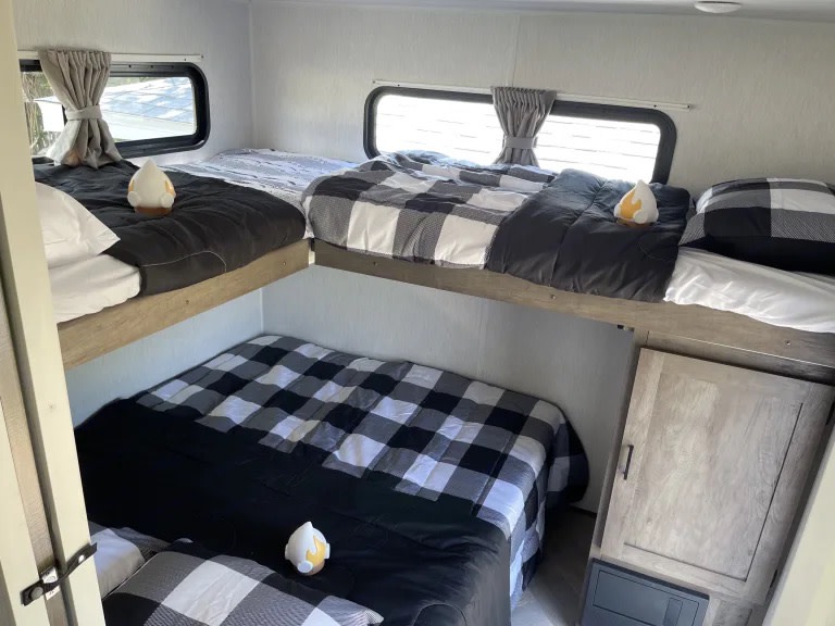 RV rental interior featuring cozy bunk beds with black and white plaid bedding, providing comfortable sleeping space.. Forest River Salem 2022