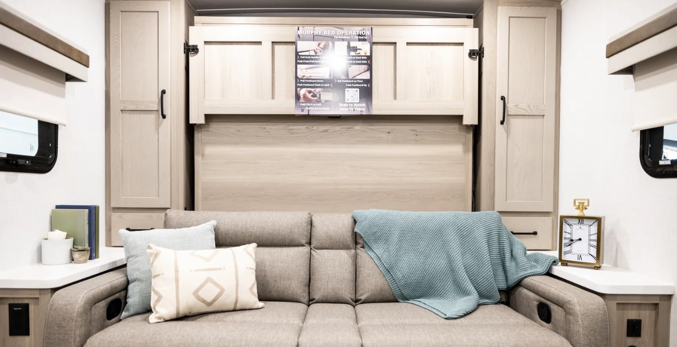 Cozy RV rental interior with a versatile sofa and hidden Murphy bed. Perfect for maximizing space and comfort on your adventure.. Forest River Rockwood Mini Lite 2023