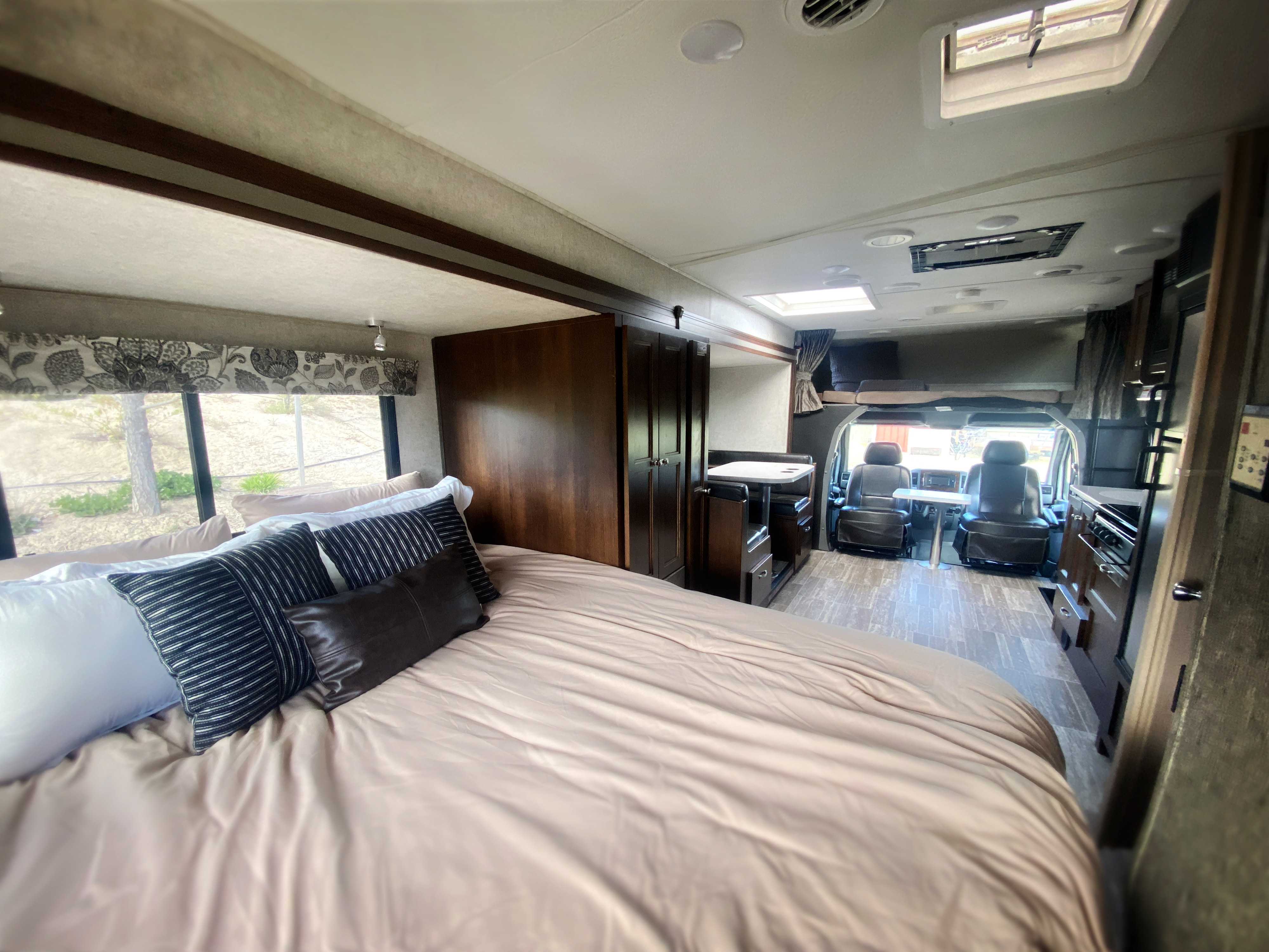 Full interior view of an **RV rental**: includes a comfortable bedroom, dining area, kitchen, and front cockpit. Your adventure starts here!. Forest River Mercedes Benz 2017