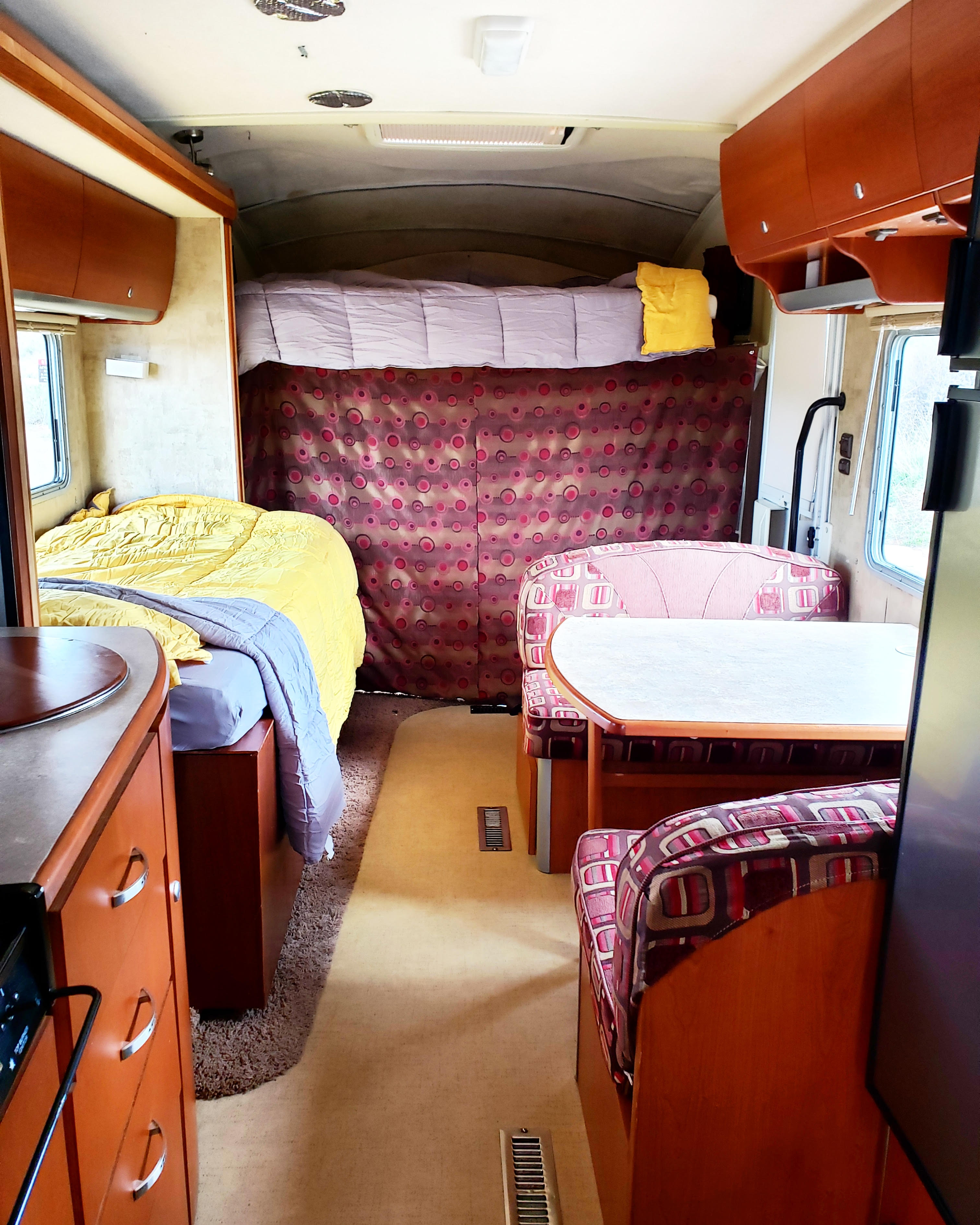 This rv rental interior offers a comfortable sleeping area, dinette, and compact kitchen.. Itasca Navion 2007