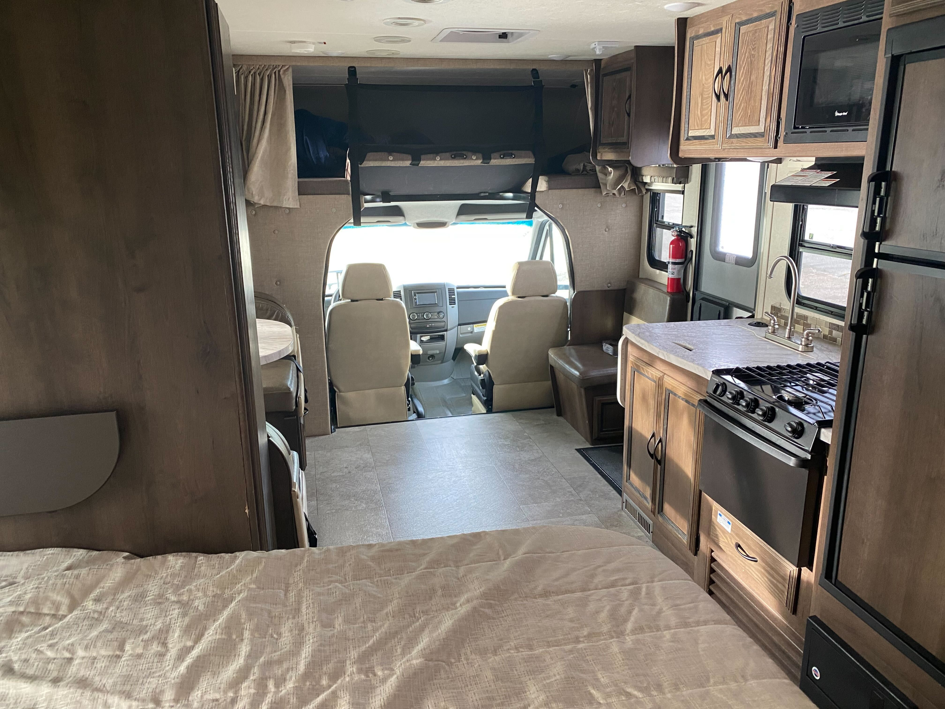 Inside an RV rental: full view from the bedroom to the cockpit, featuring kitchen, dinette, and overhead bunk.. Coachmen Mercedes Sprinter 2018